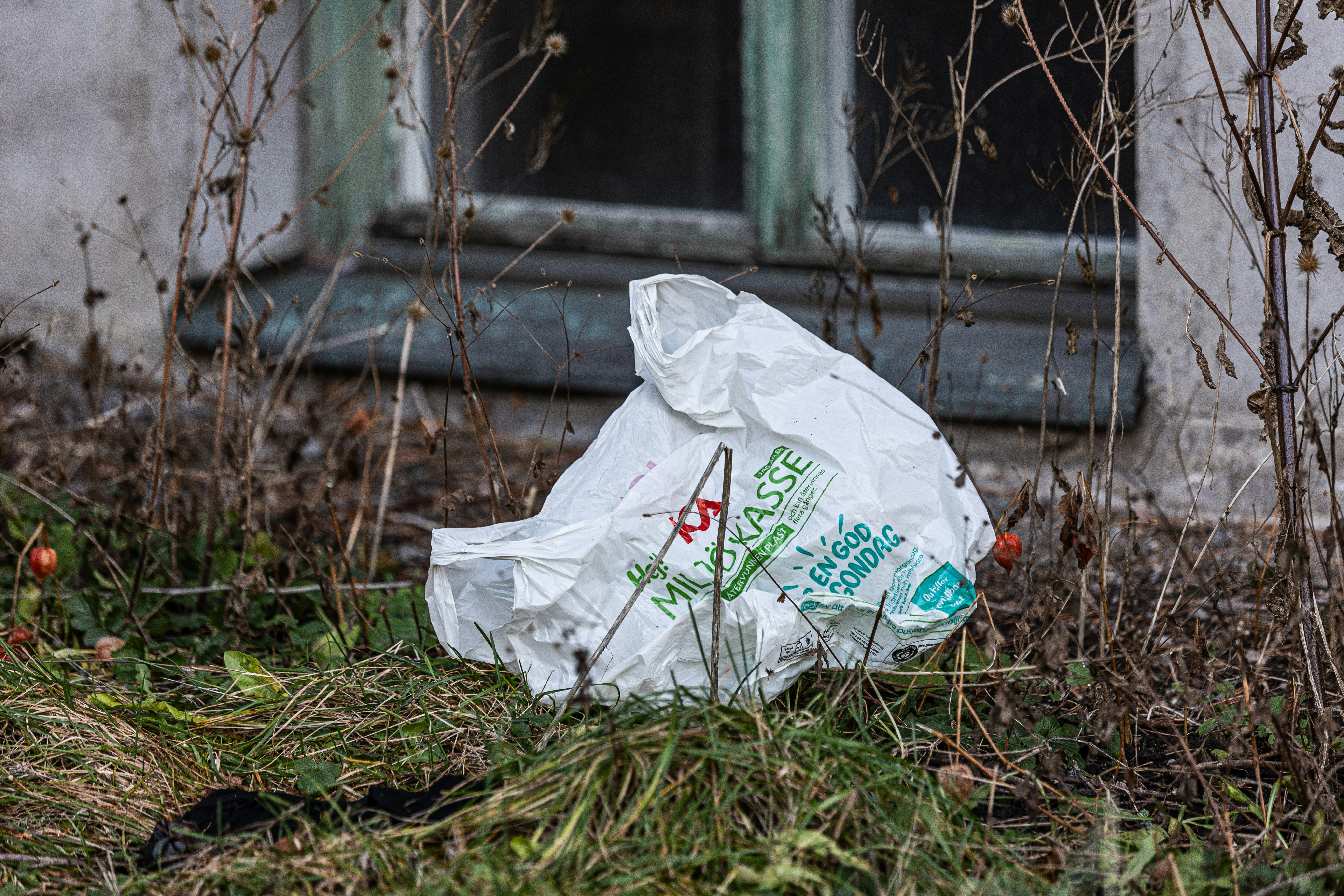 A plastic bag sitting on the ground in front of a window