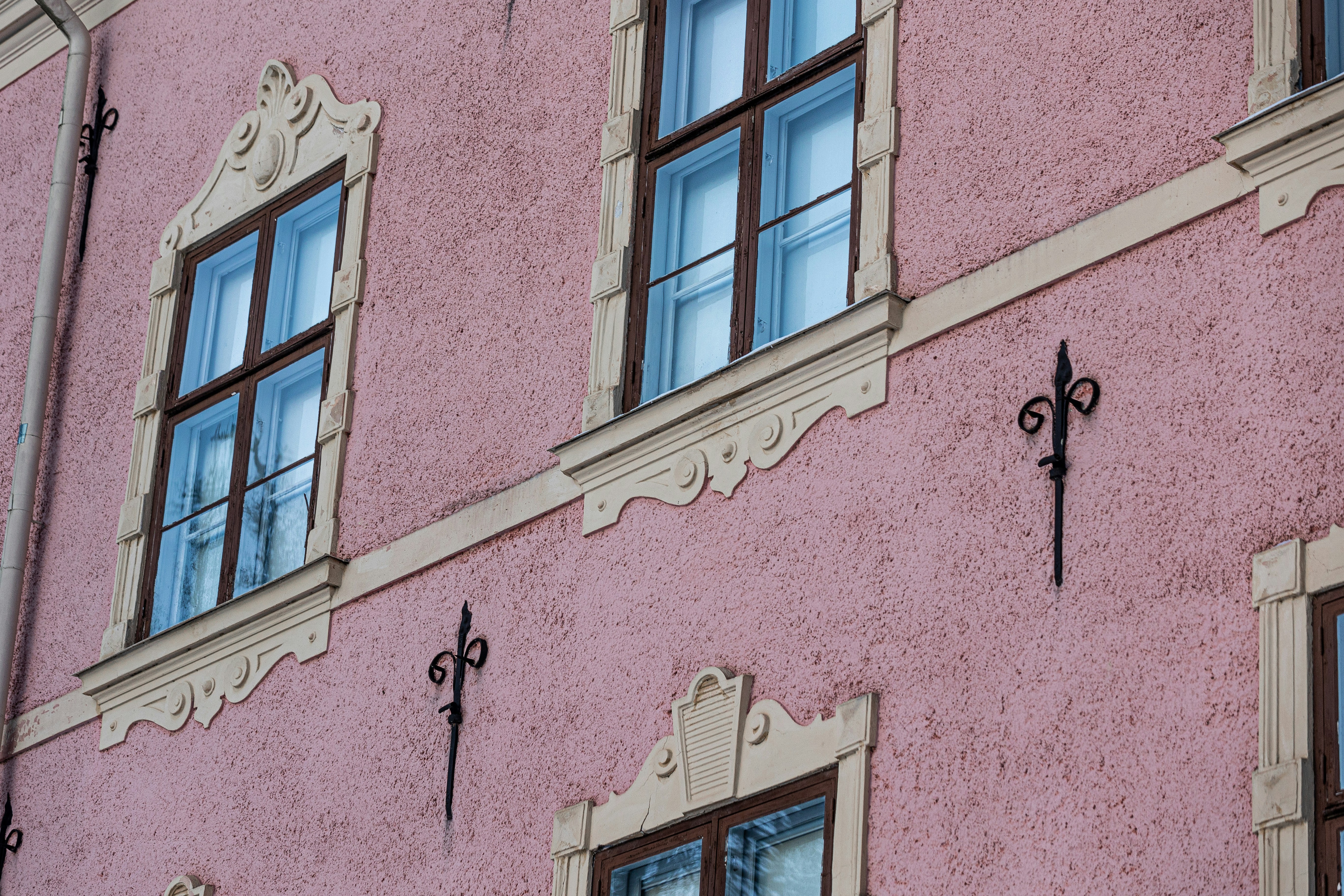 A pink building with a clock on the side of it