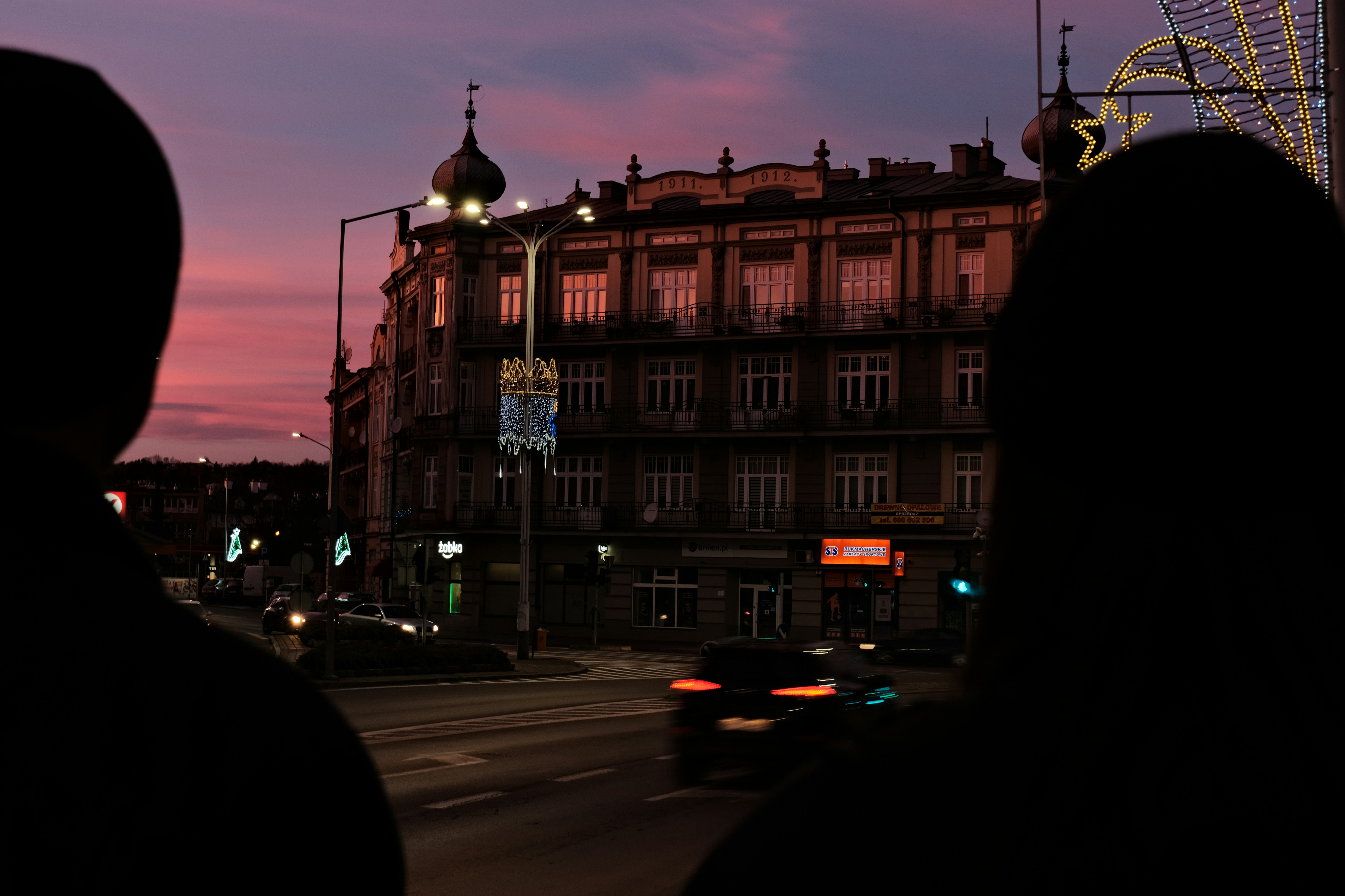 A person looking out a window at a city street