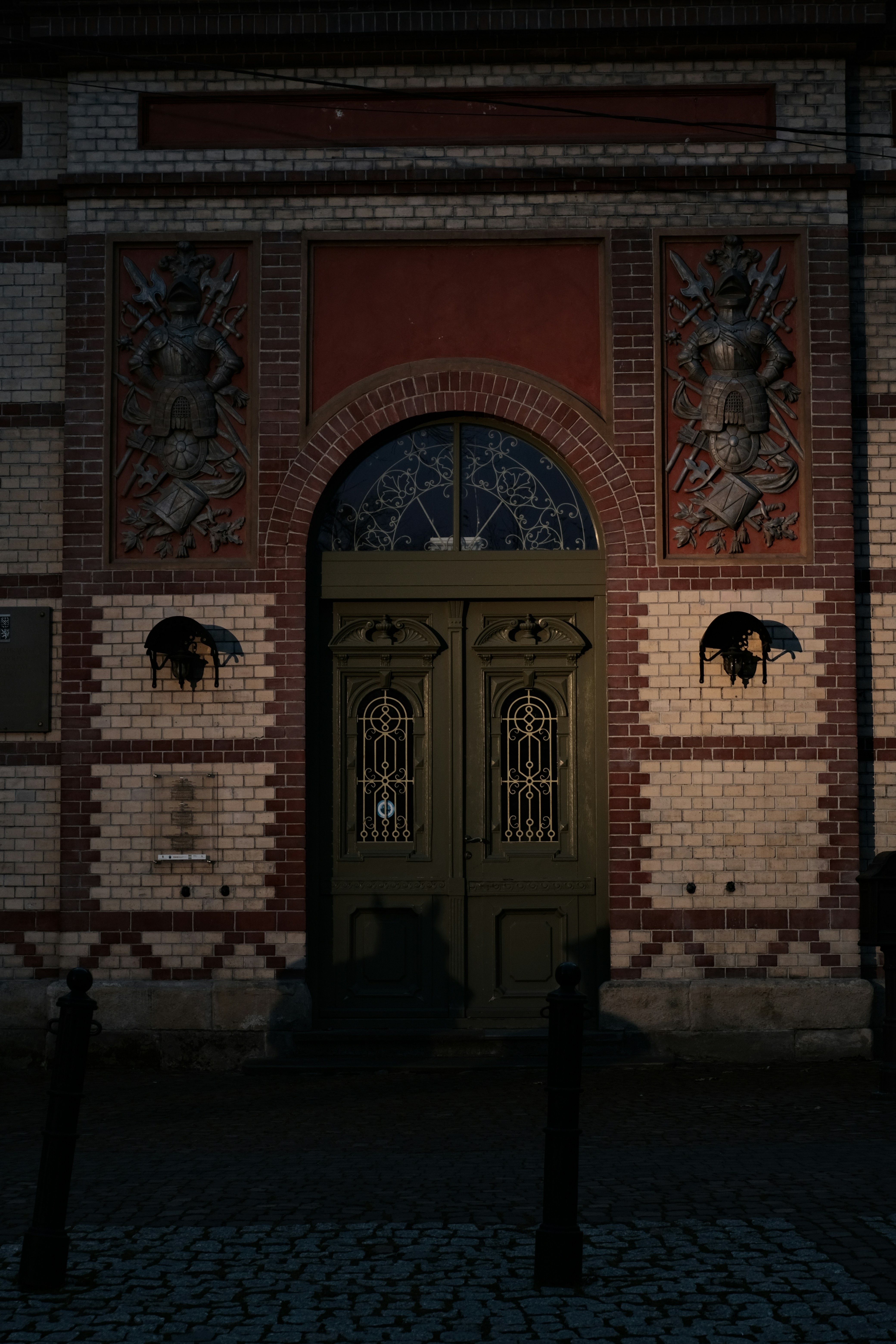 A building with two doors and a clock on the side of it