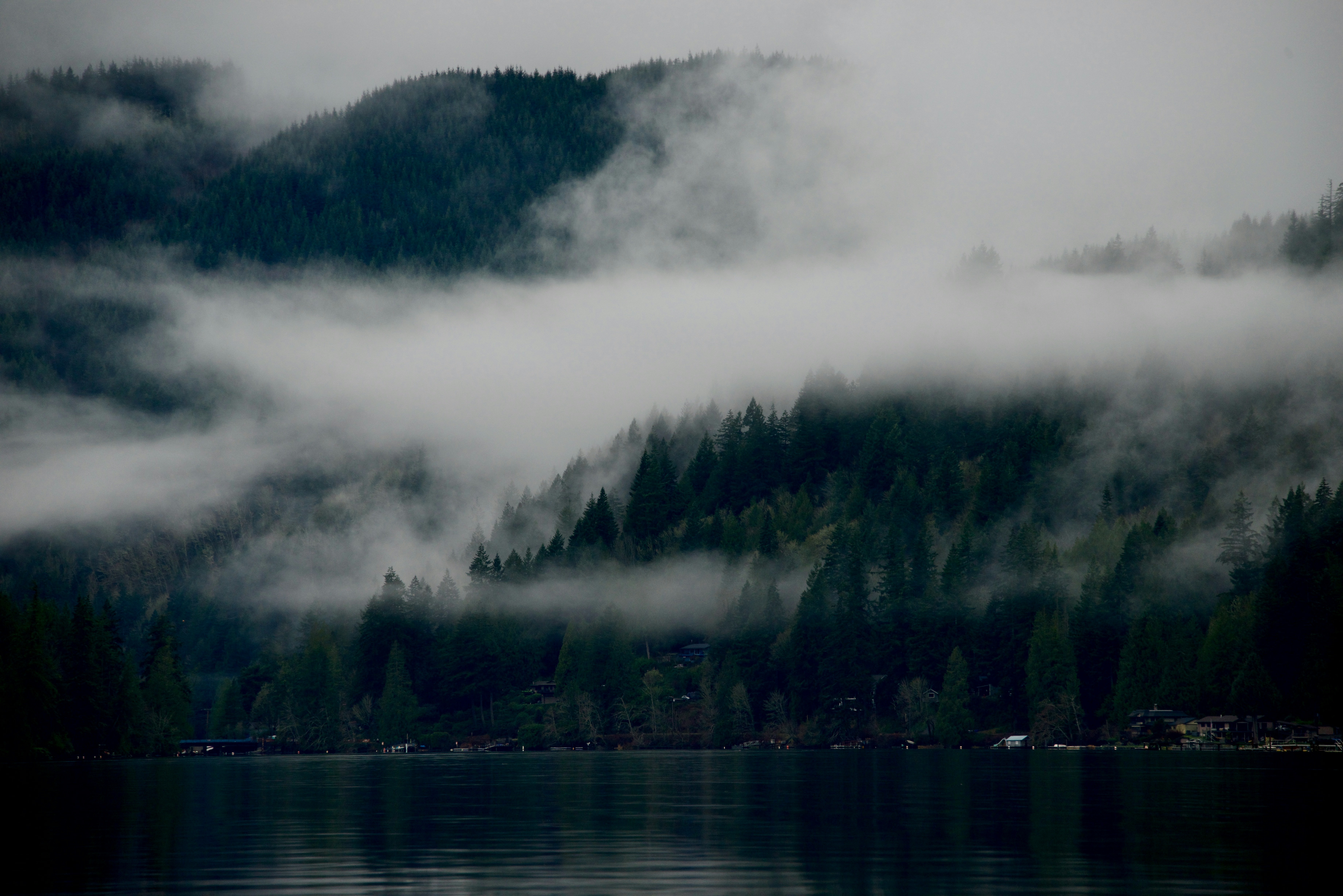 Un cuerpo de agua rodeado de montañas y nubes