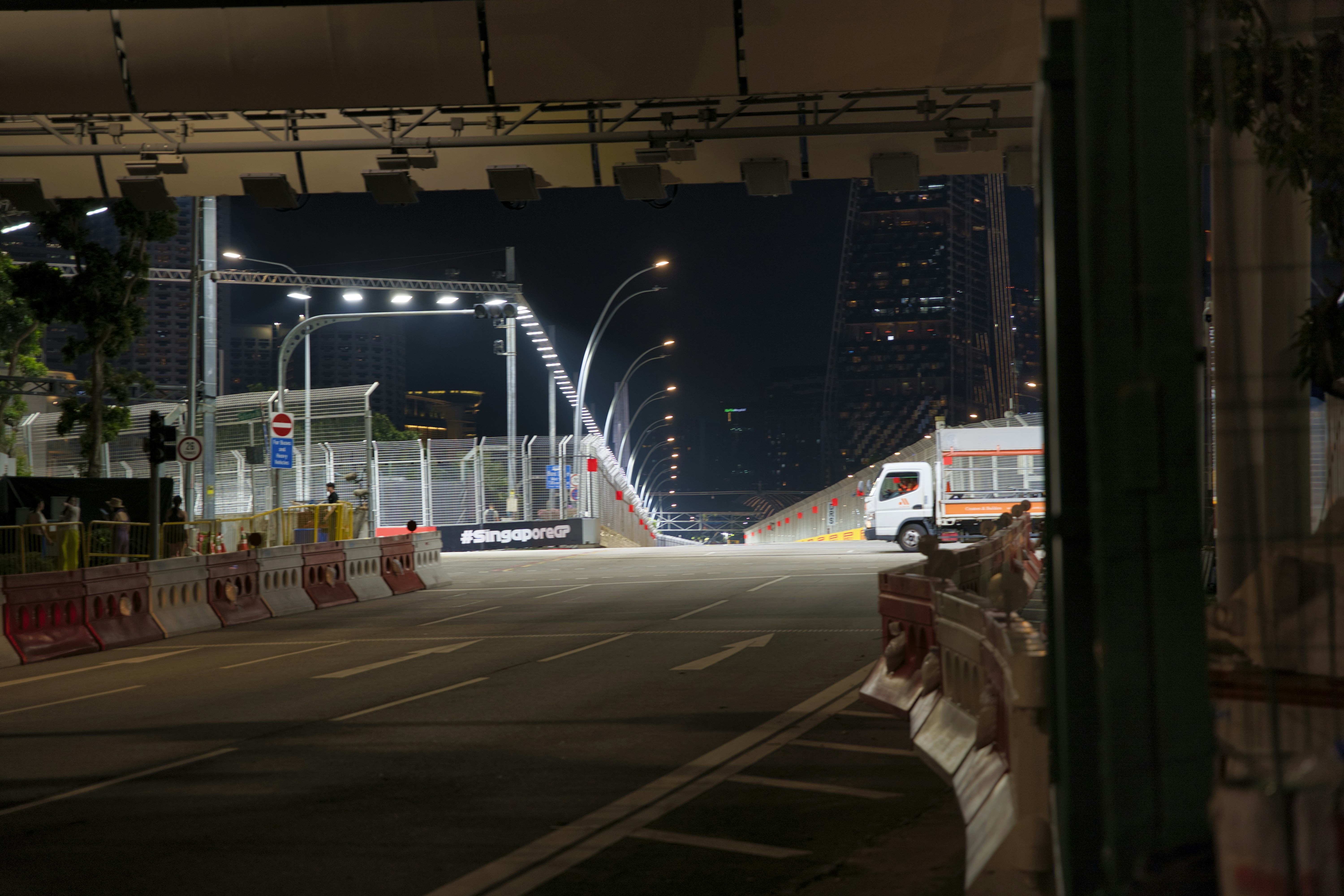 A city street at night with a train on the tracks