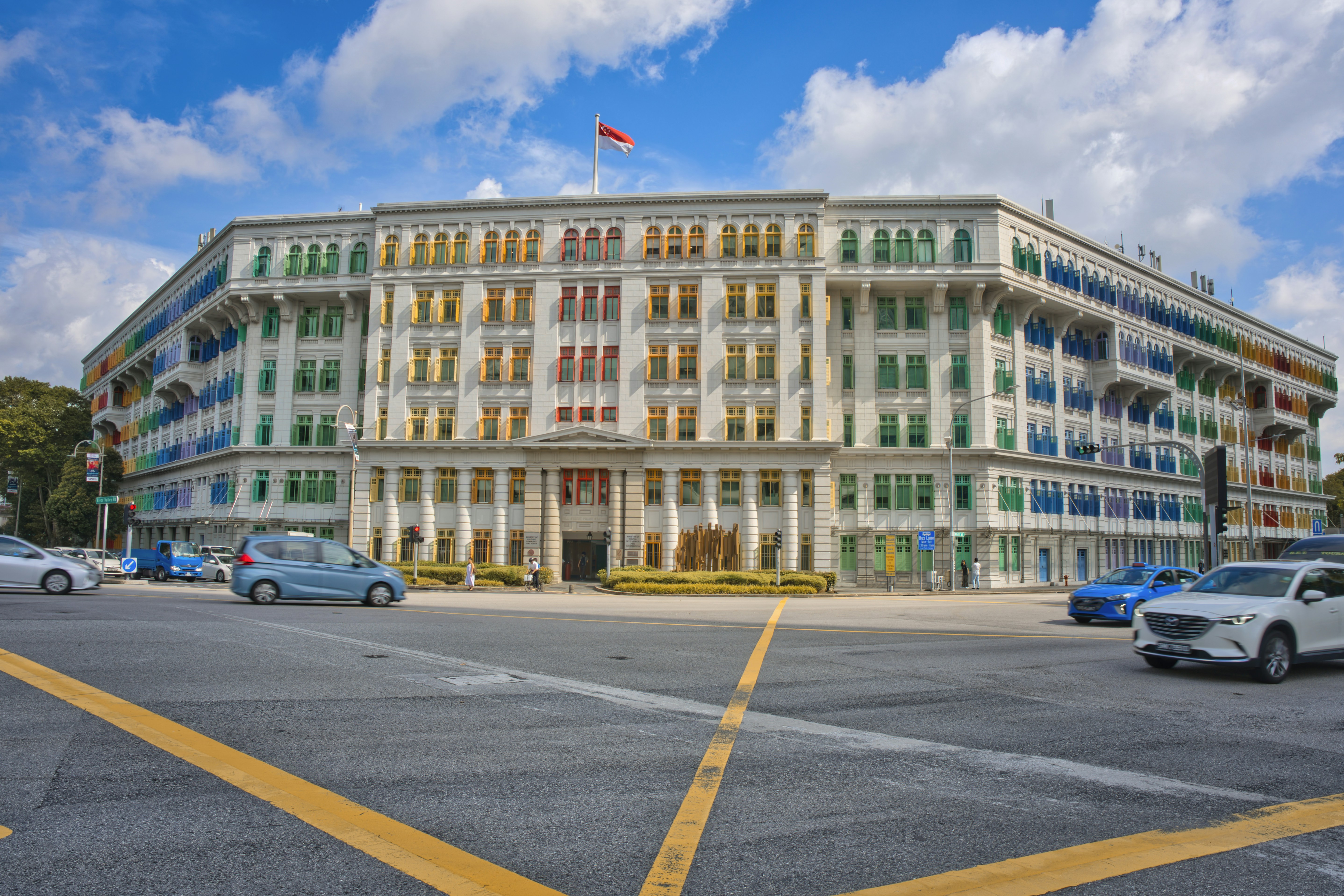 A large multi - story building with cars parked in front of it