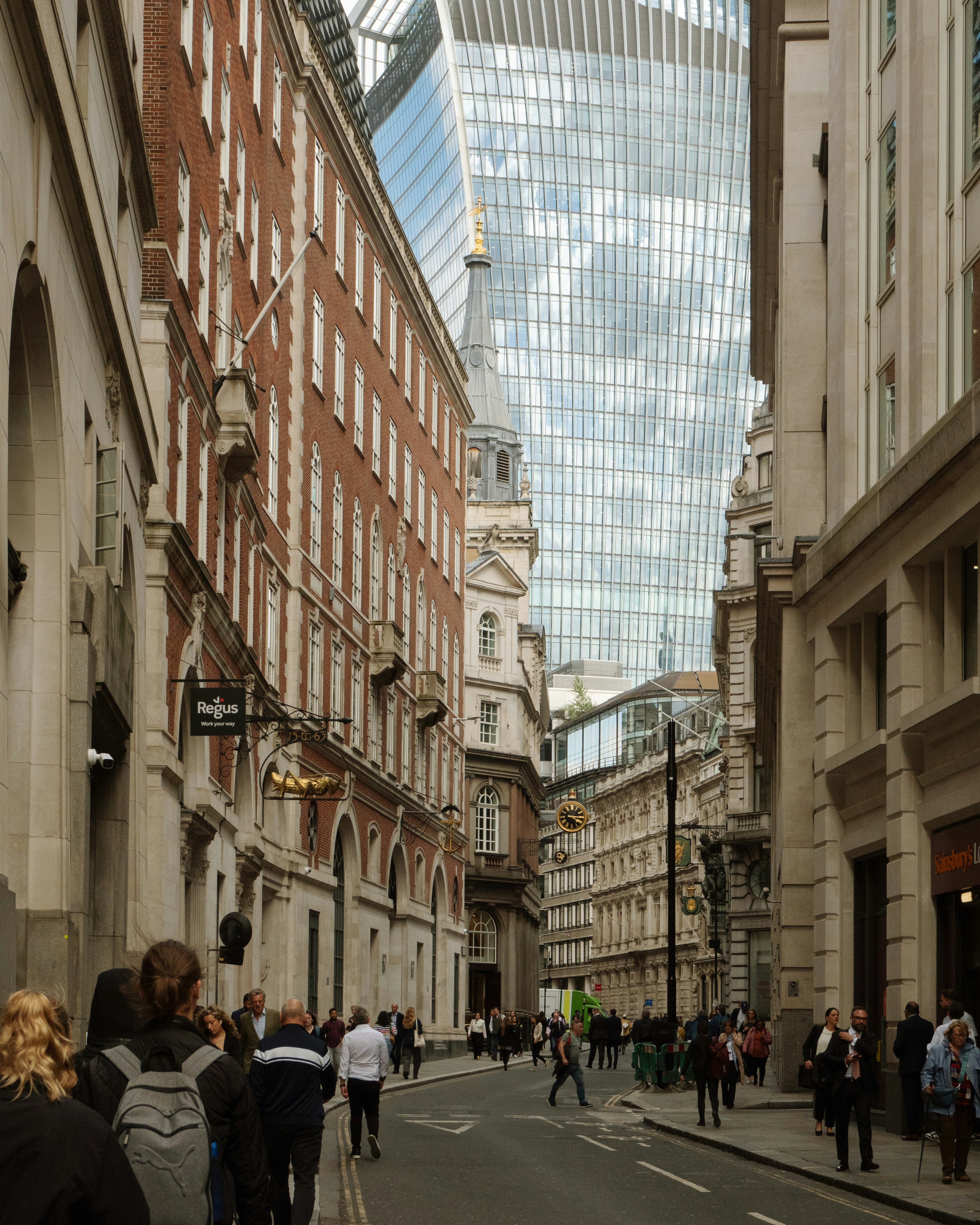 Eine Gruppe von Menschen geht eine Straße neben hohen Gebäuden entlang