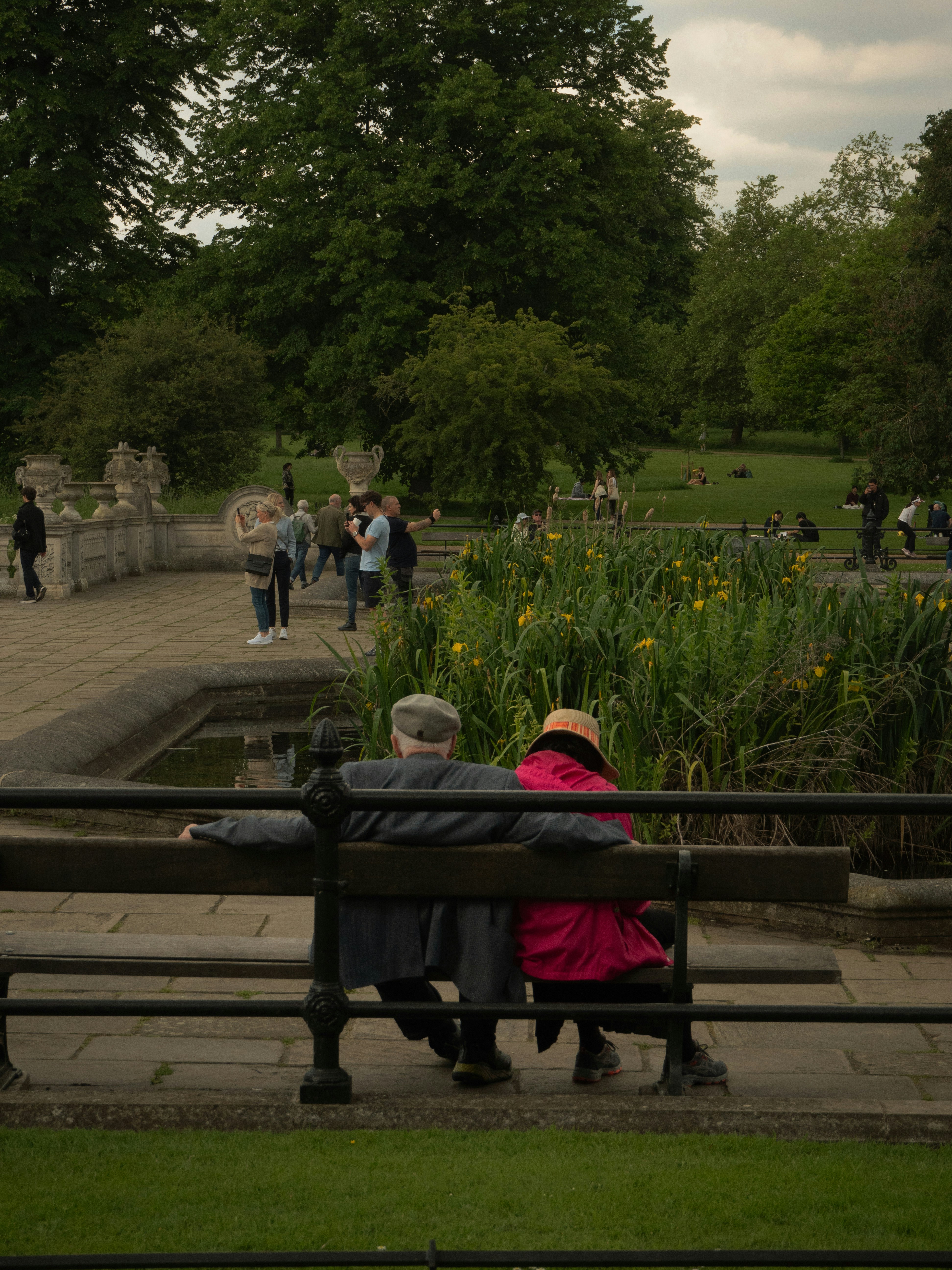 Zwei Personen sitzen auf einer Bank in einem Park