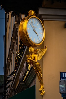 A gold angel clock on the side of a building