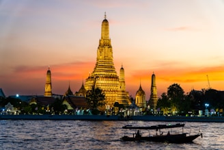 Two boats floating on the water in front of a tall building