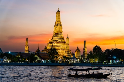 Two boats floating on the water in front of a tall building