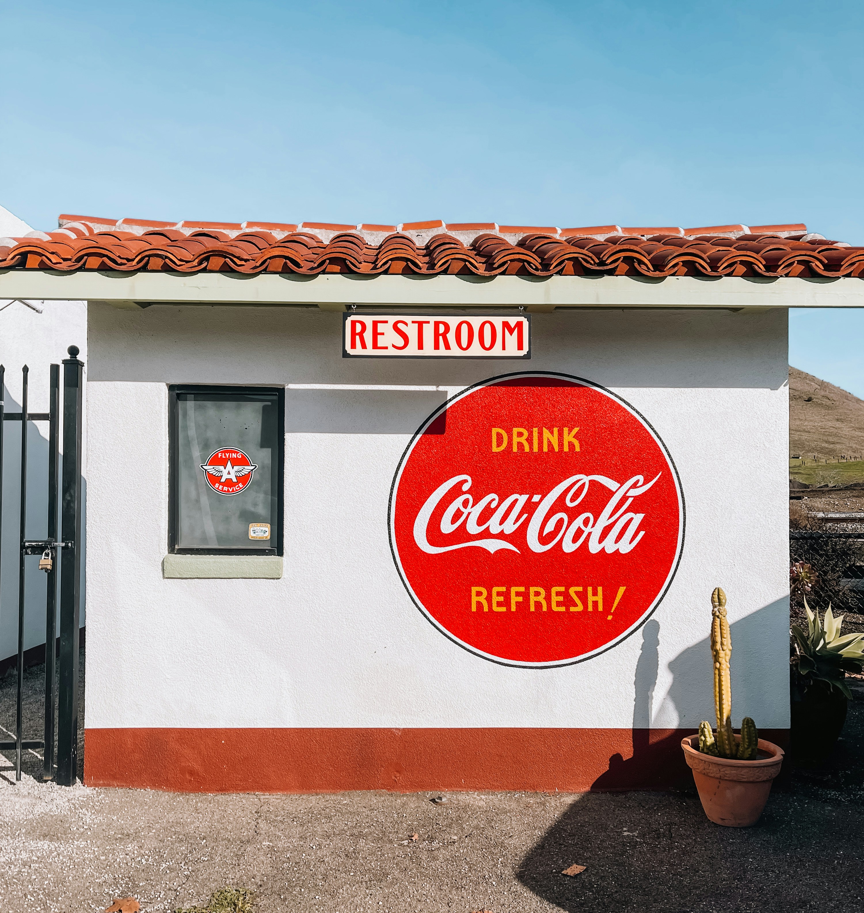 A small white building with a coca - cola sign on it