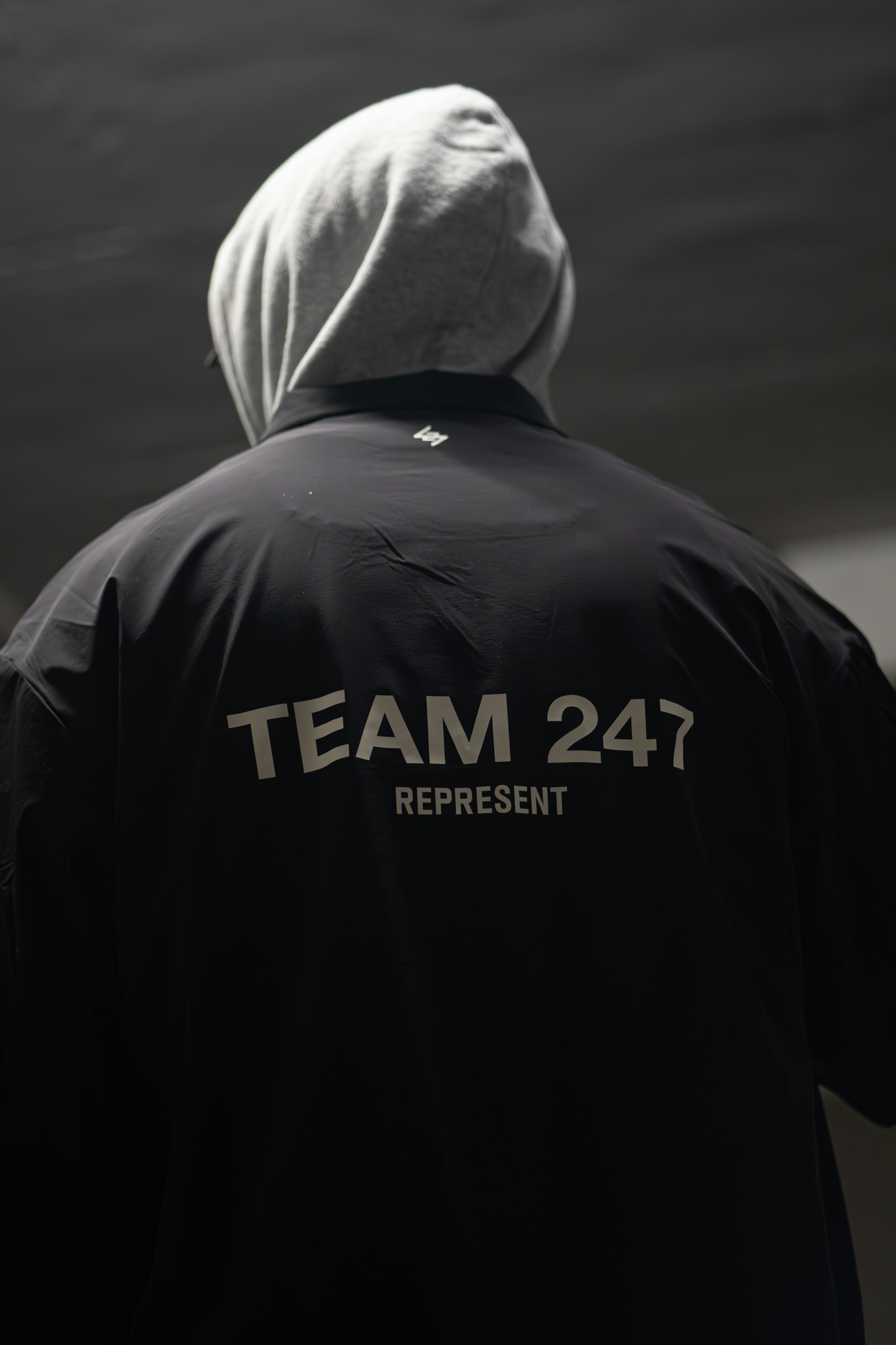 A man in a black jacket with a white hoodie