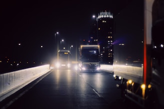 A truck driving down a highway at night