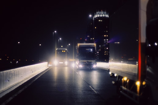 A truck driving down a highway at night