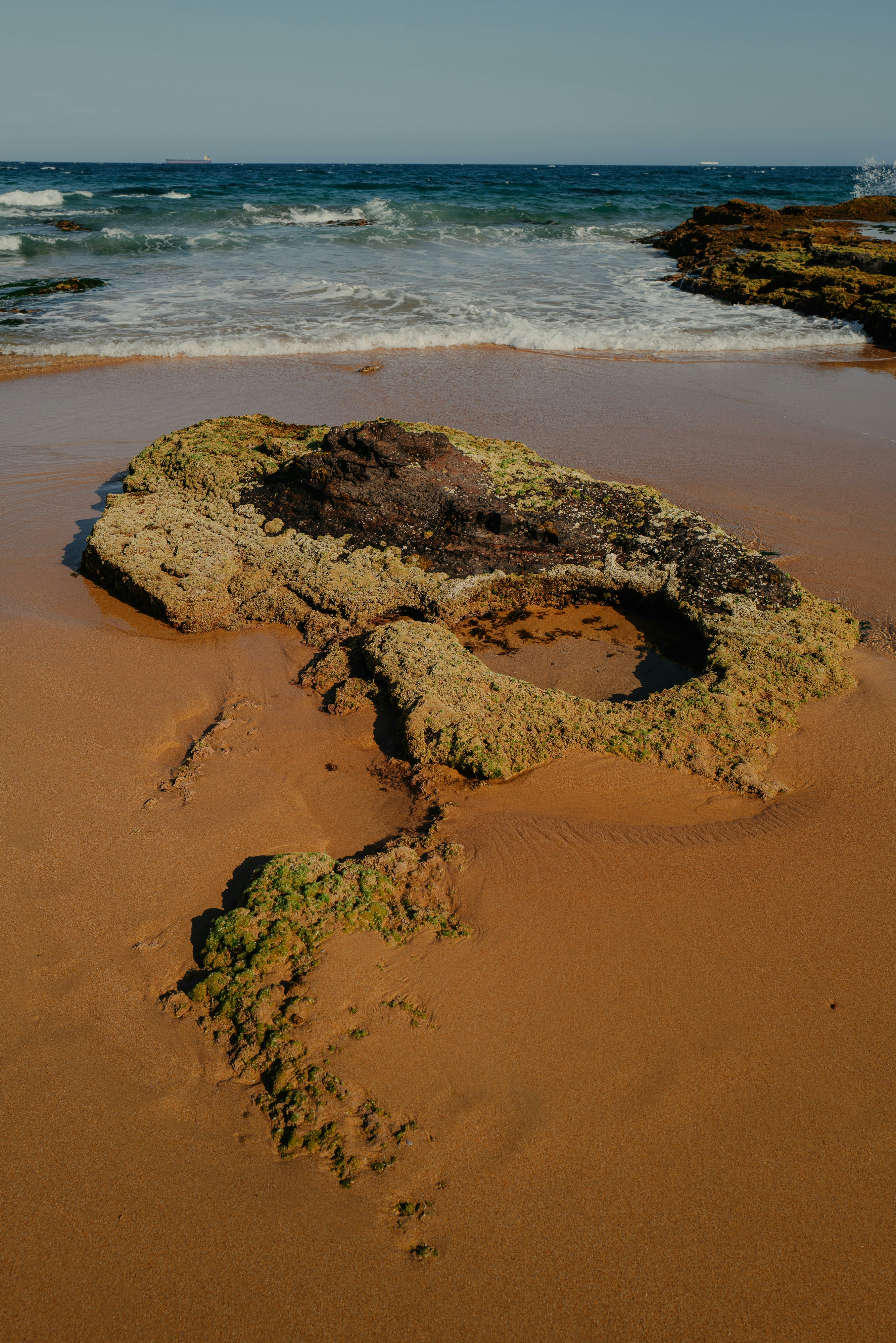 Ein Felsen, der auf einem Sandstrand liegt