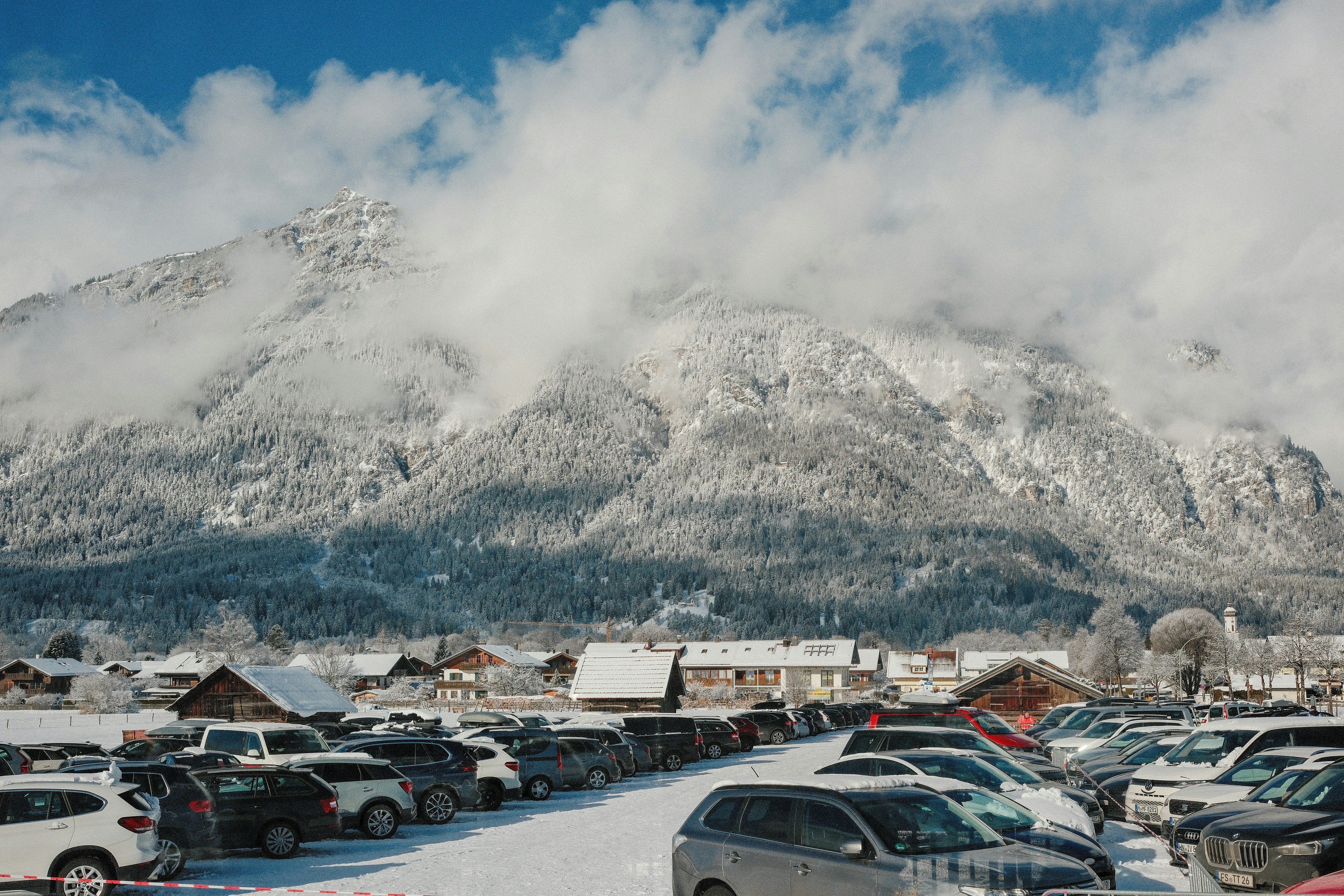 A parking lot filled with lots of cars covered in snow