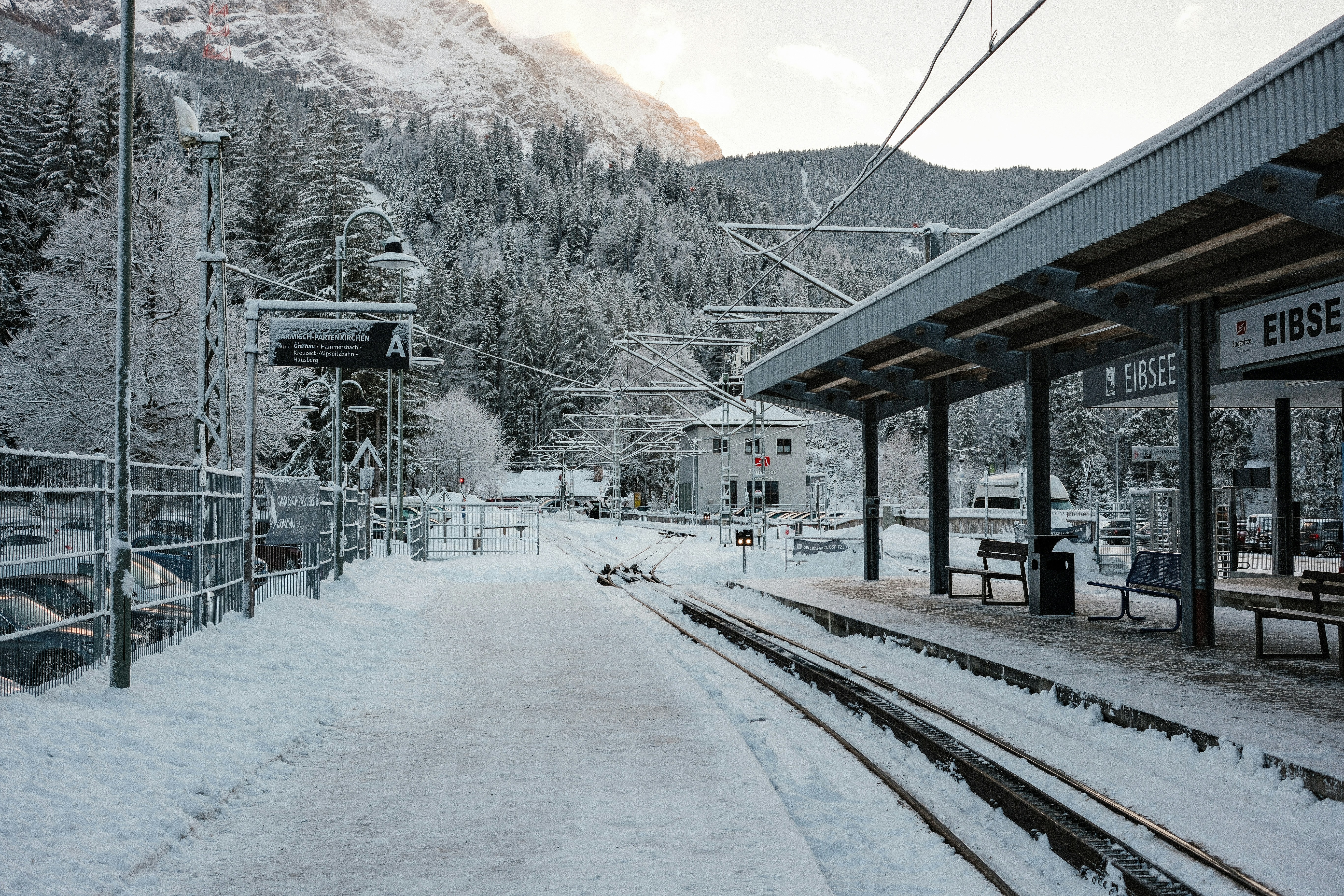 Ein schneebedeckter Bahnhof neben einem Berg
