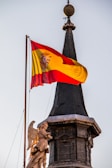 A statue with a flag on top of a building
