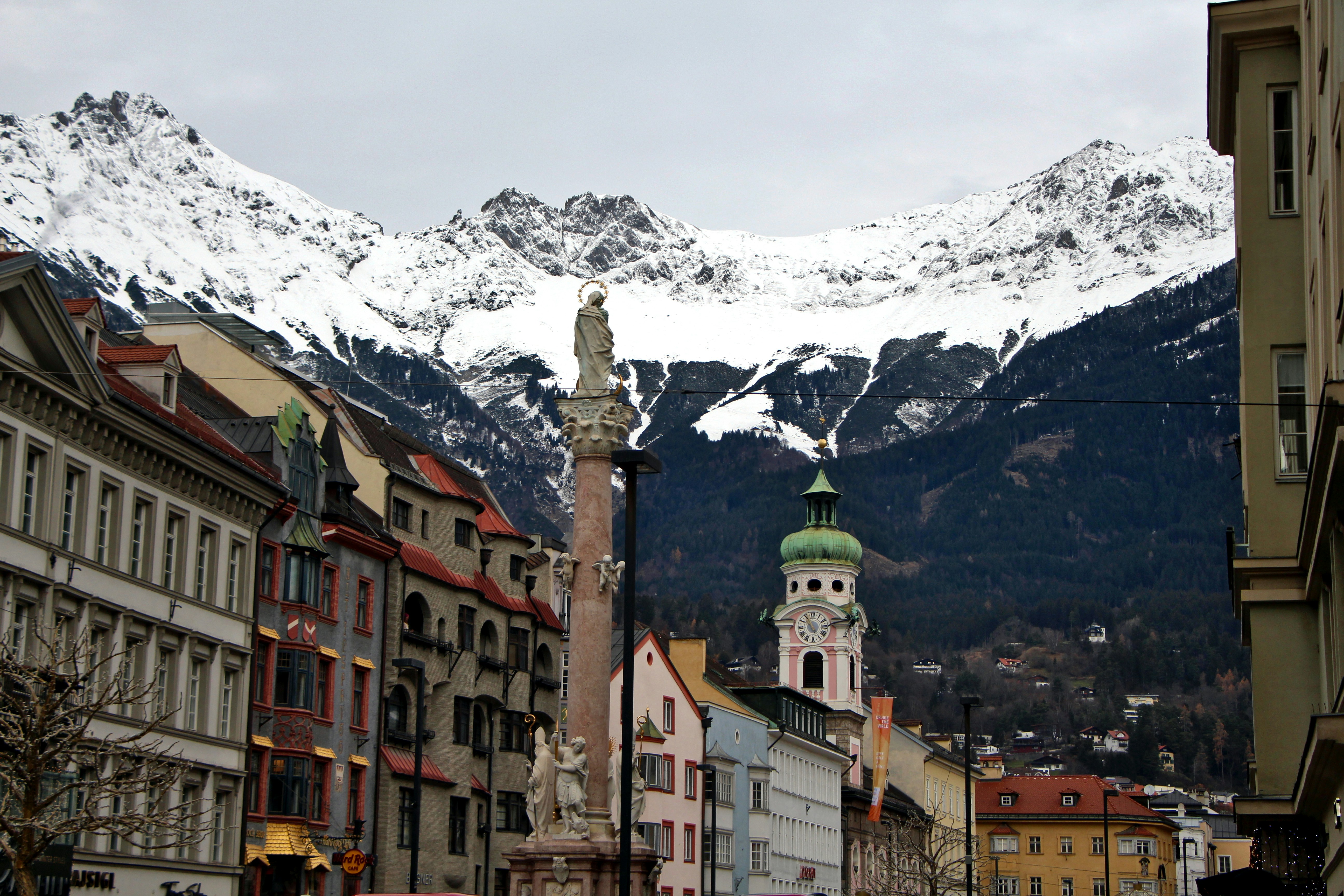 A city street with buildings and mountains in the background