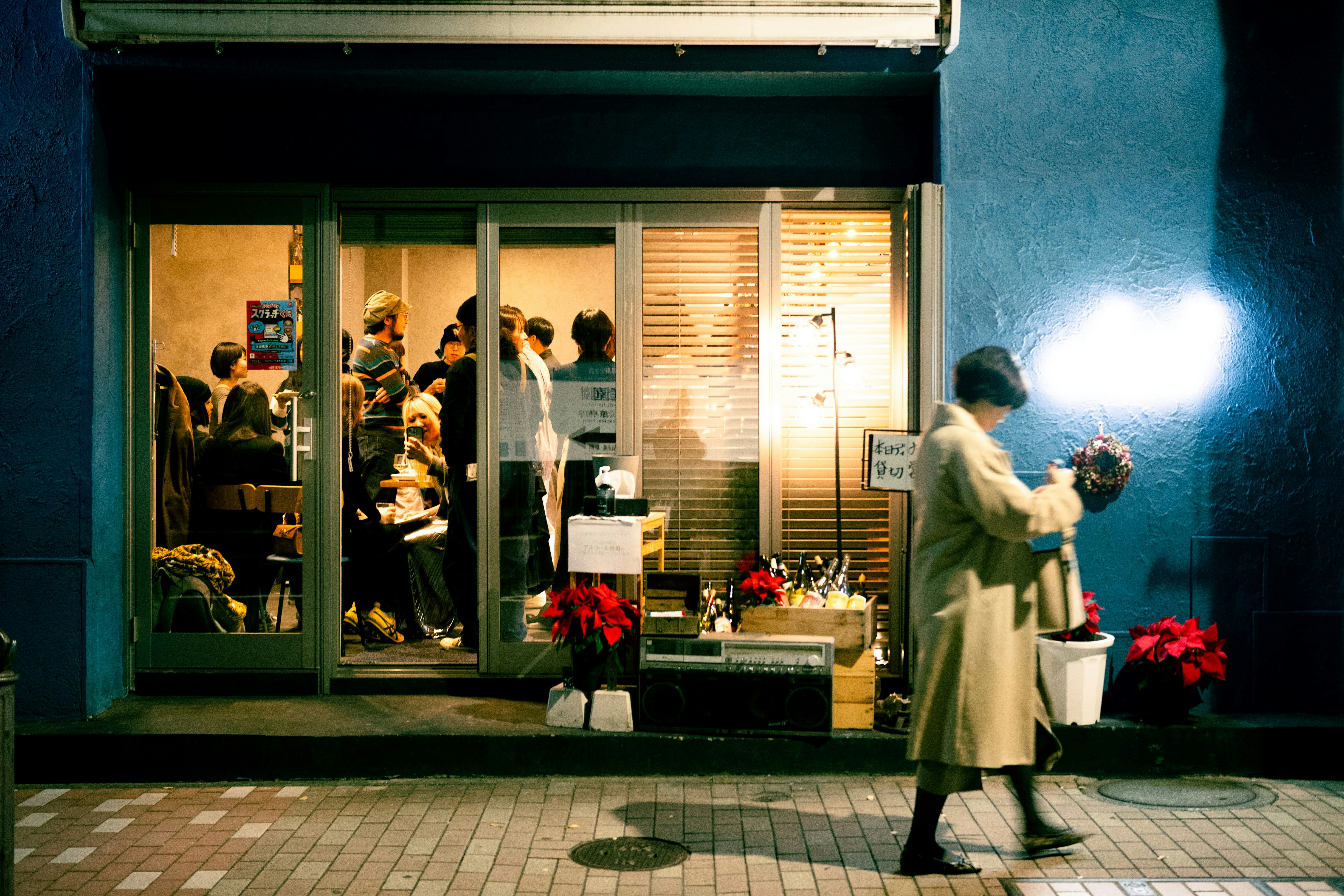 A man standing in front of a store at night