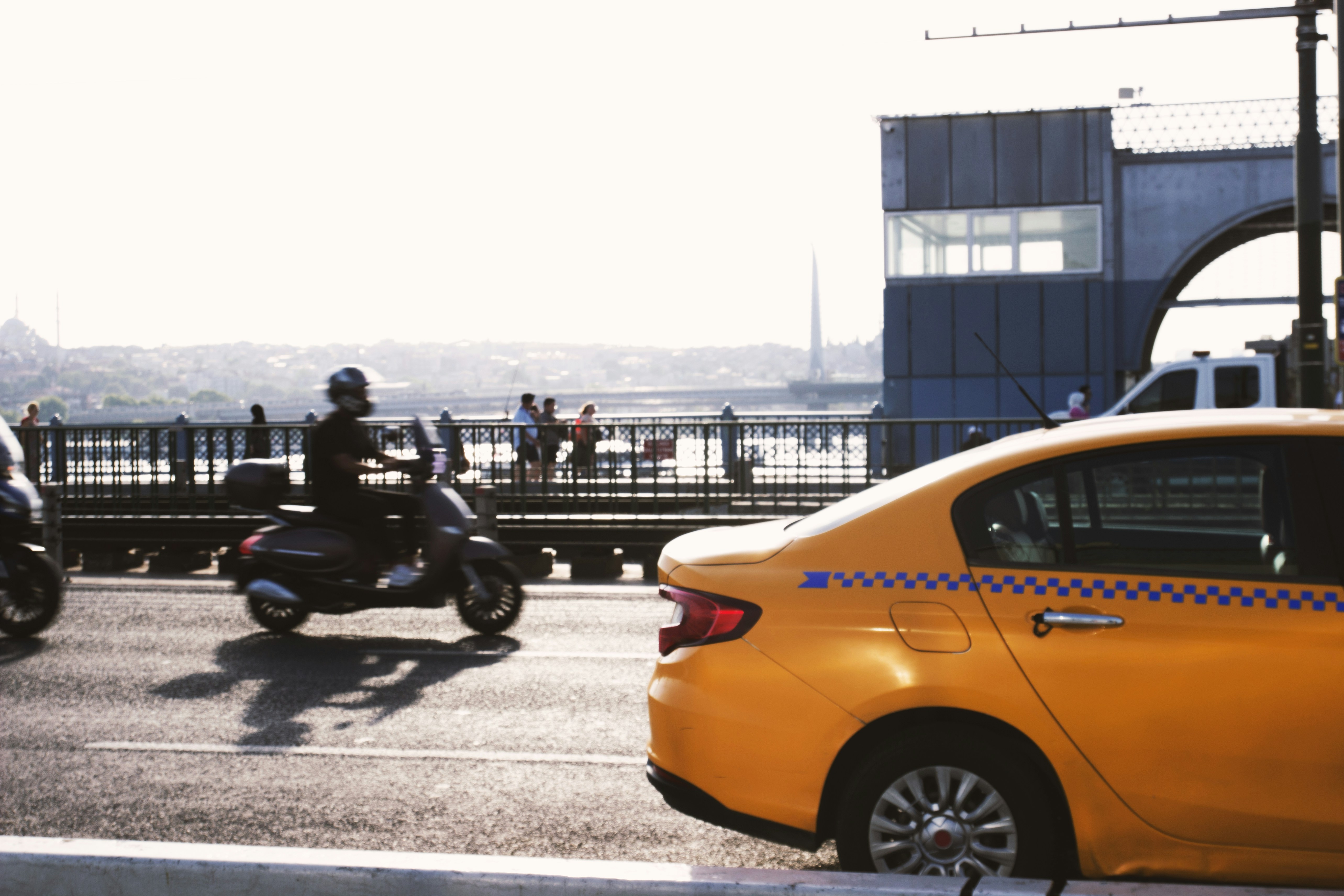 A yellow taxi cab parked next to a motorcycle