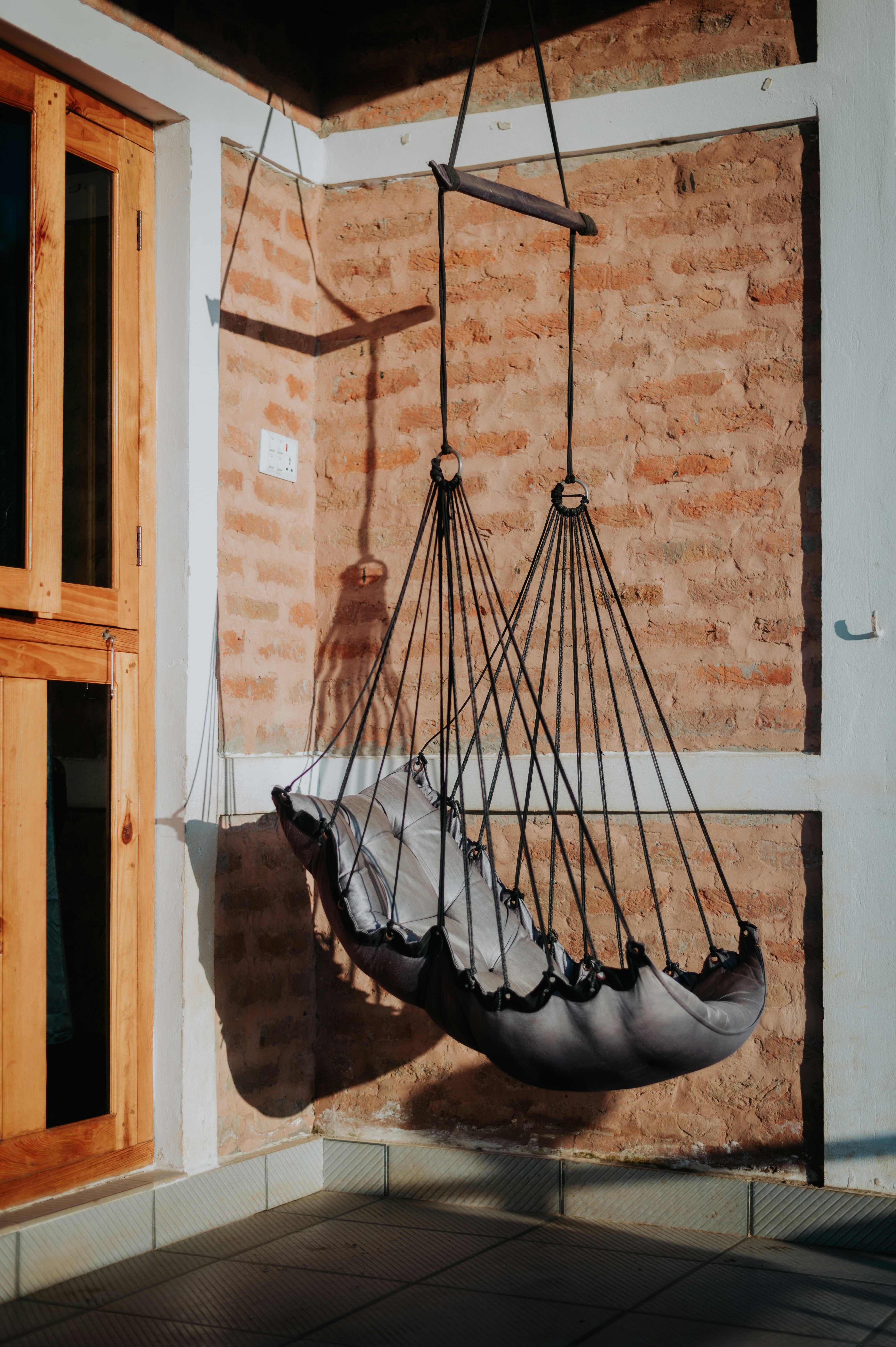 A hammock hanging from a brick wall