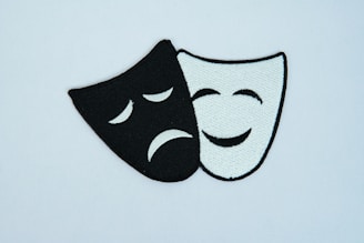A black and white mask with a sad face