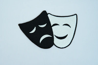 A black and white mask with a sad face