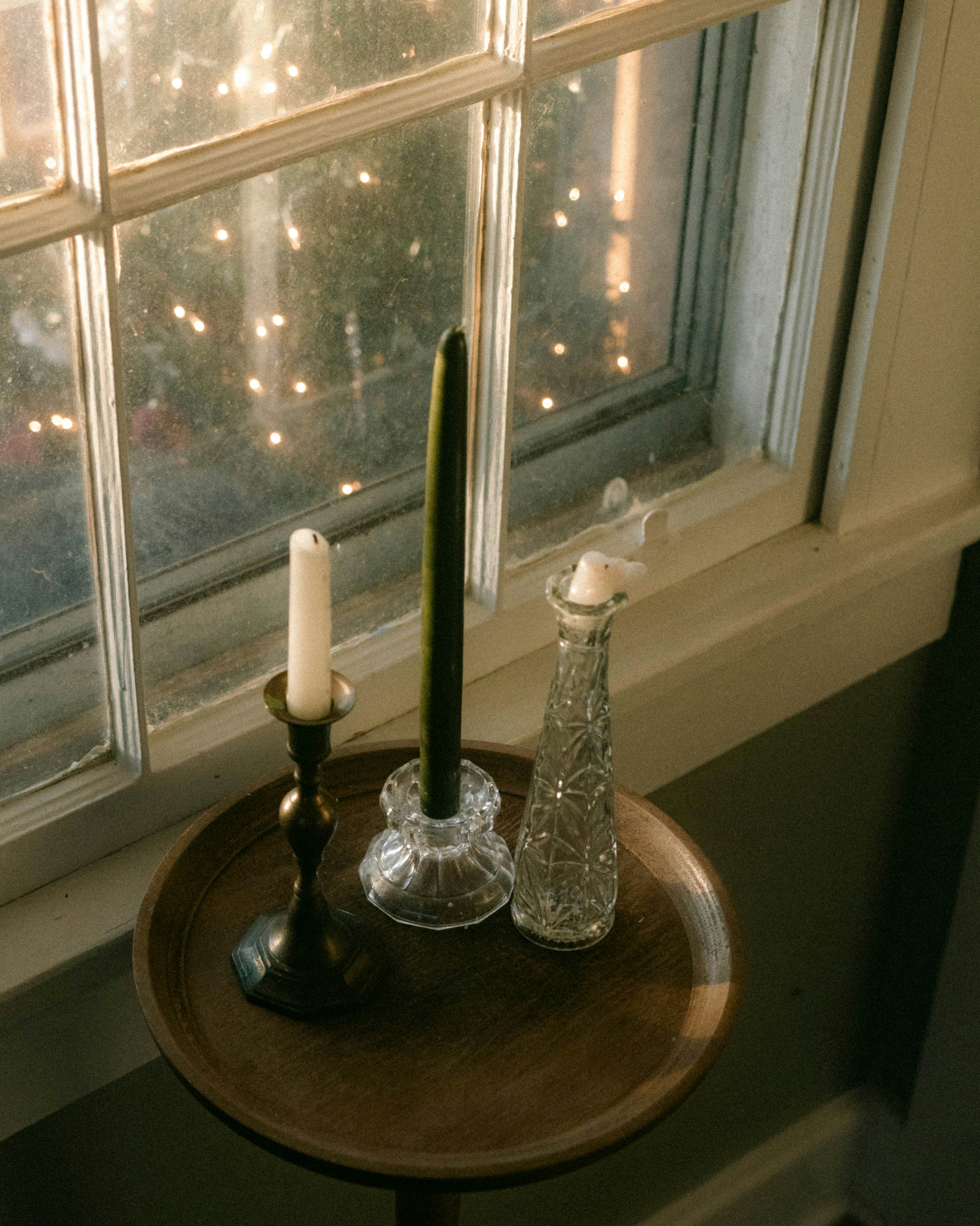 A small table with a candle and a vase on it