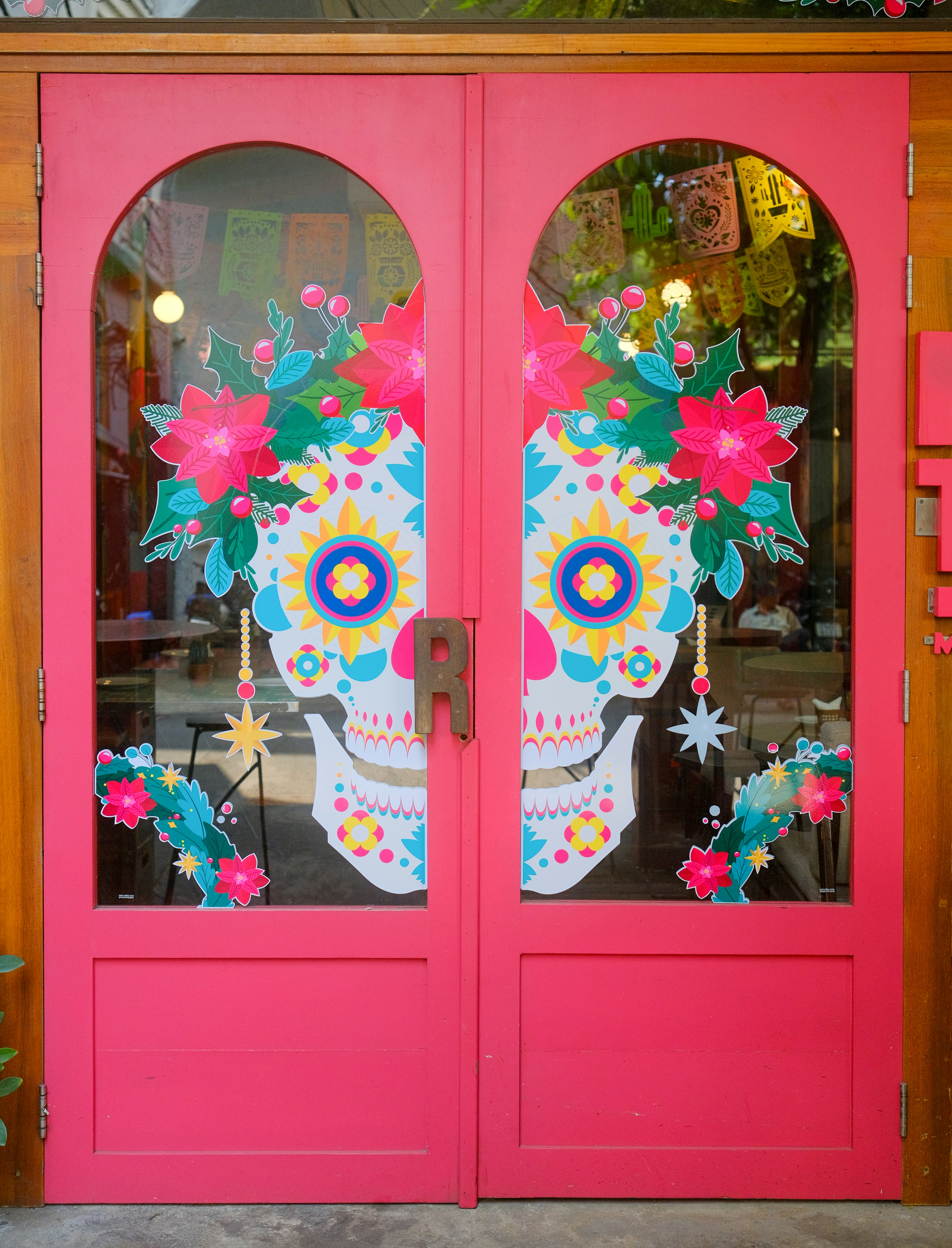 A pink door with a sugar skull painted on it