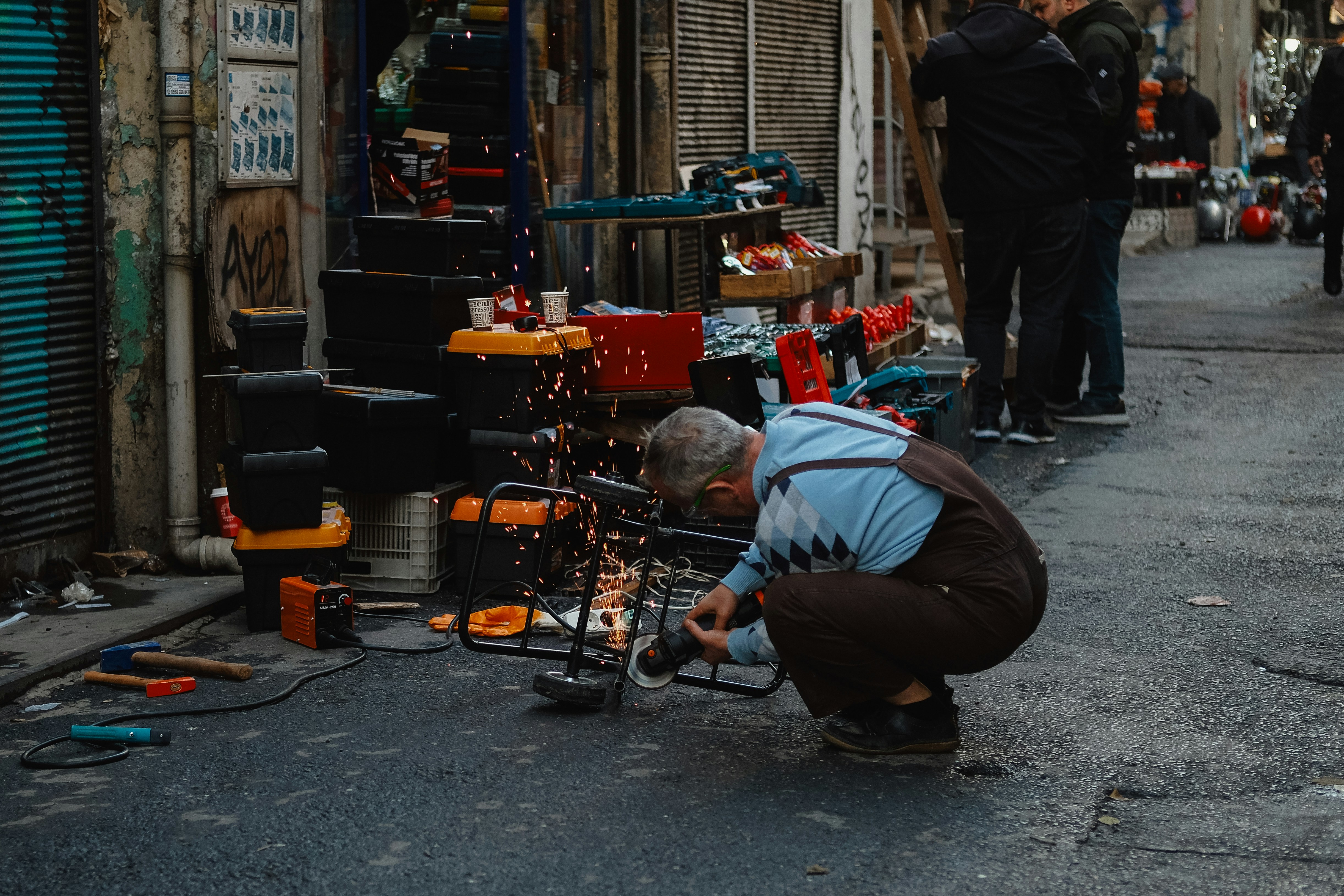 A man kneeling down next to a pile of tools