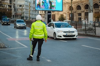 A person in a yellow jacket is standing on the street
