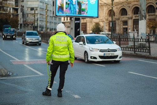 A person in a yellow jacket is standing on the street