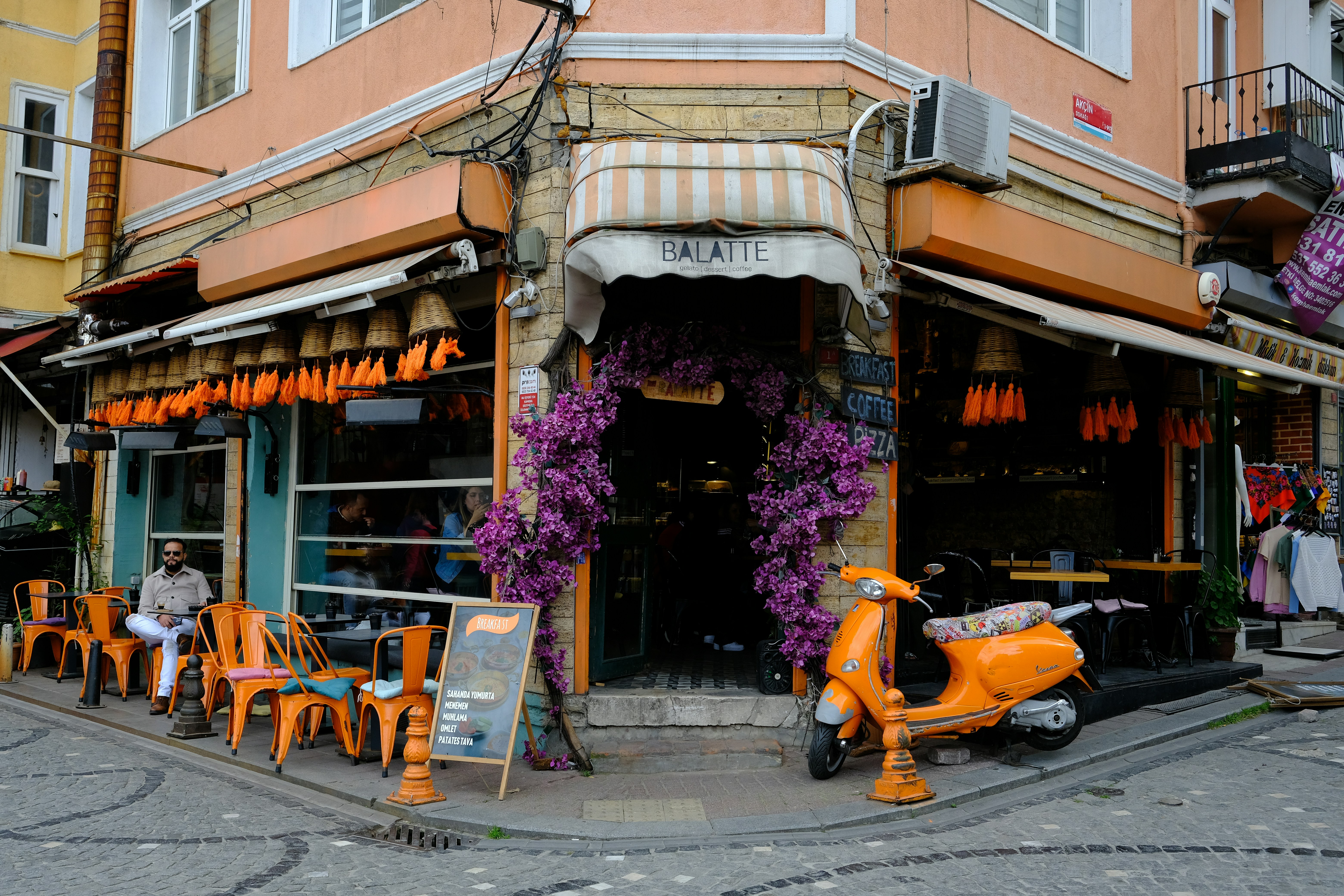 An orange scooter parked in front of a building