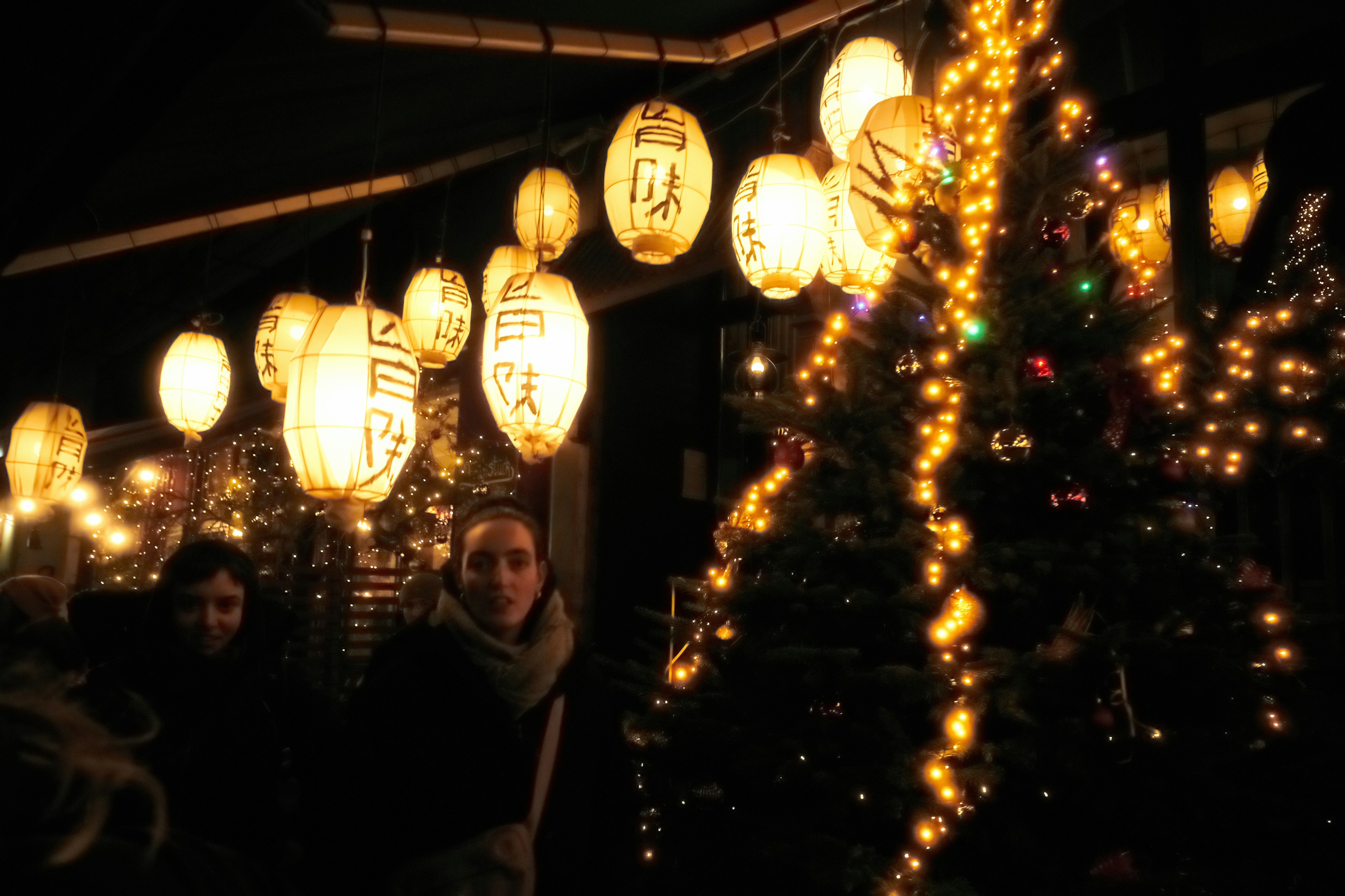 A group of people standing in front of a christmas tree