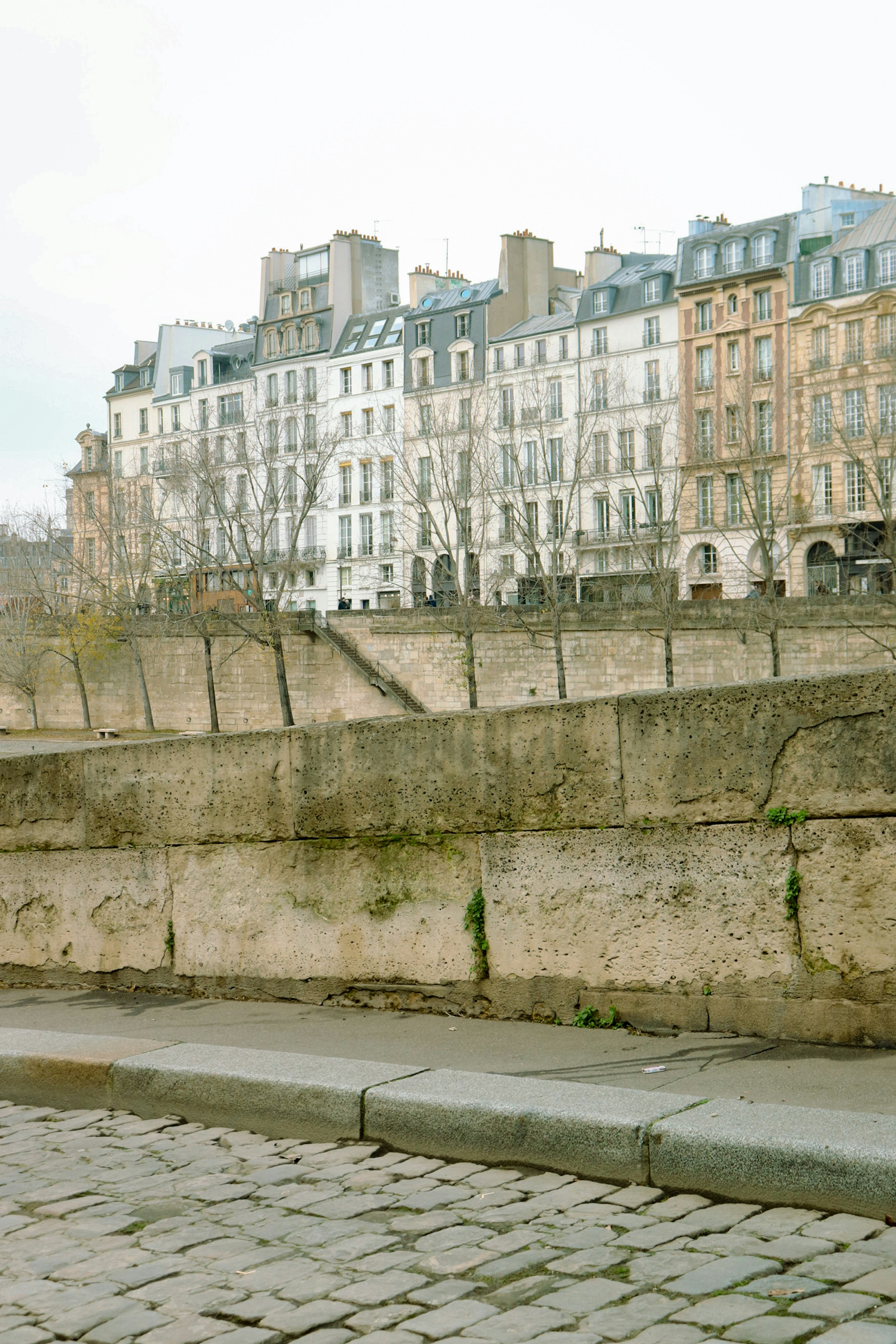 A man riding a skateboard down a cobblestone street