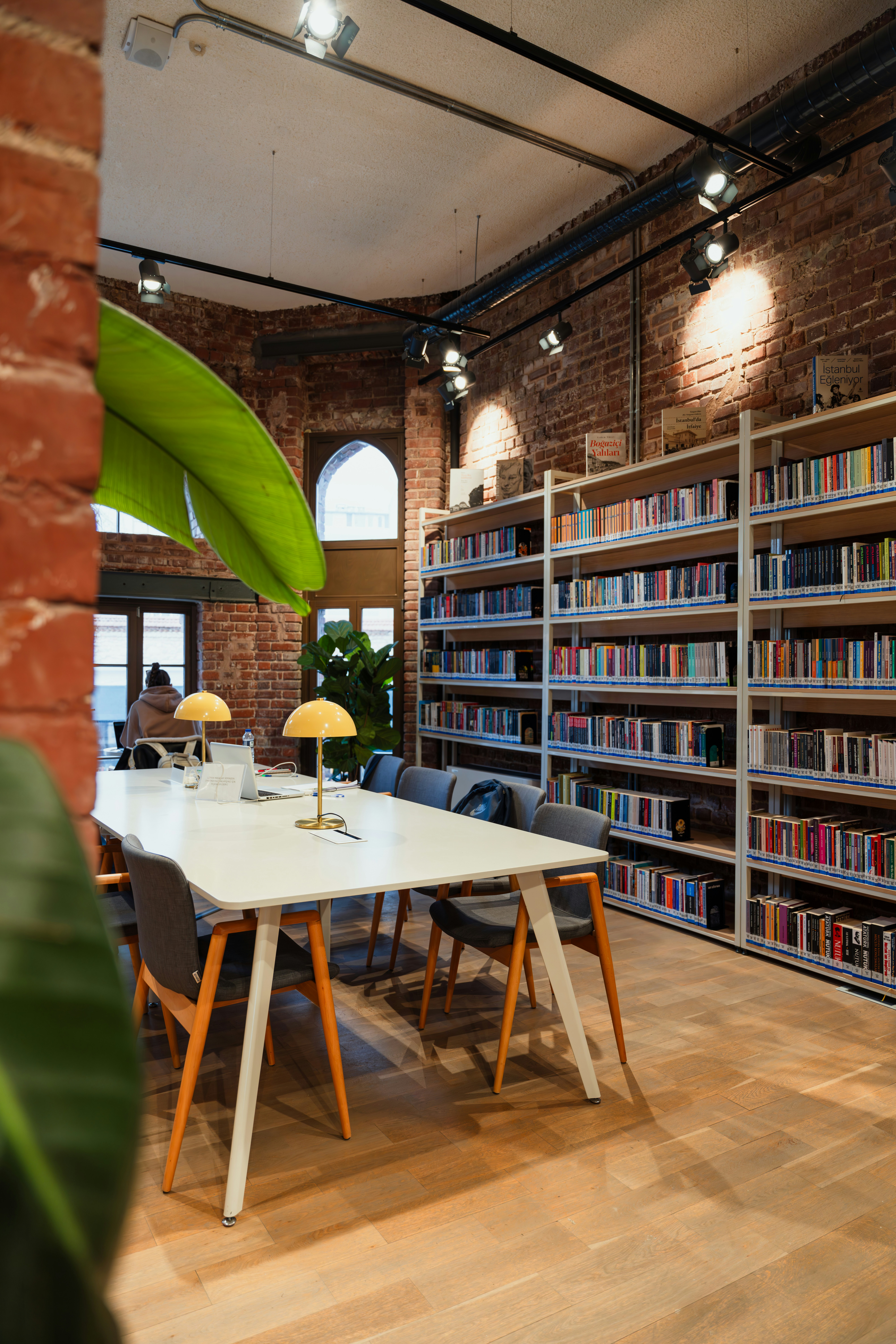A library with a table and chairs and bookshelves photo – Free Human ...