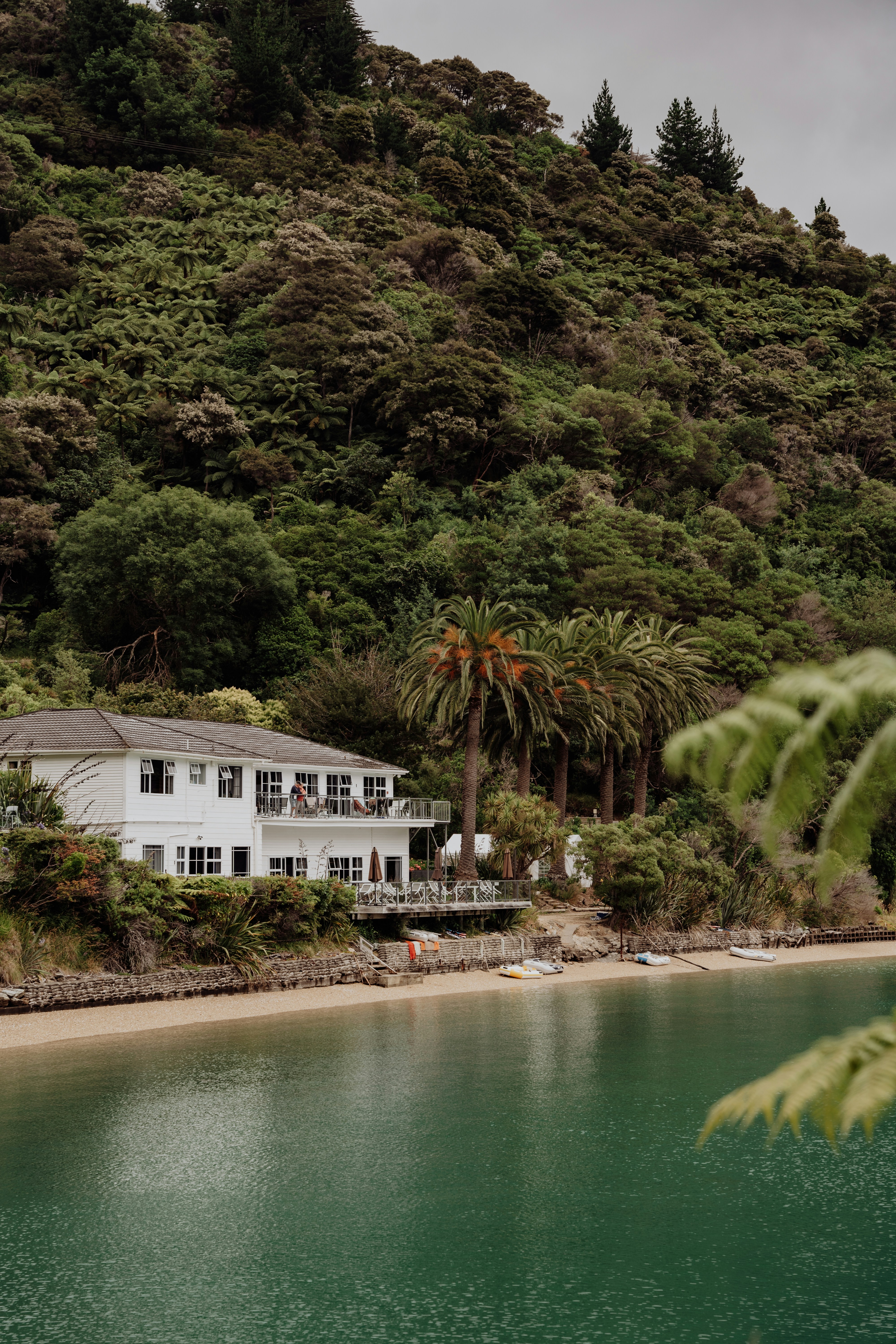 A large white house sitting on top of a lush green hillside