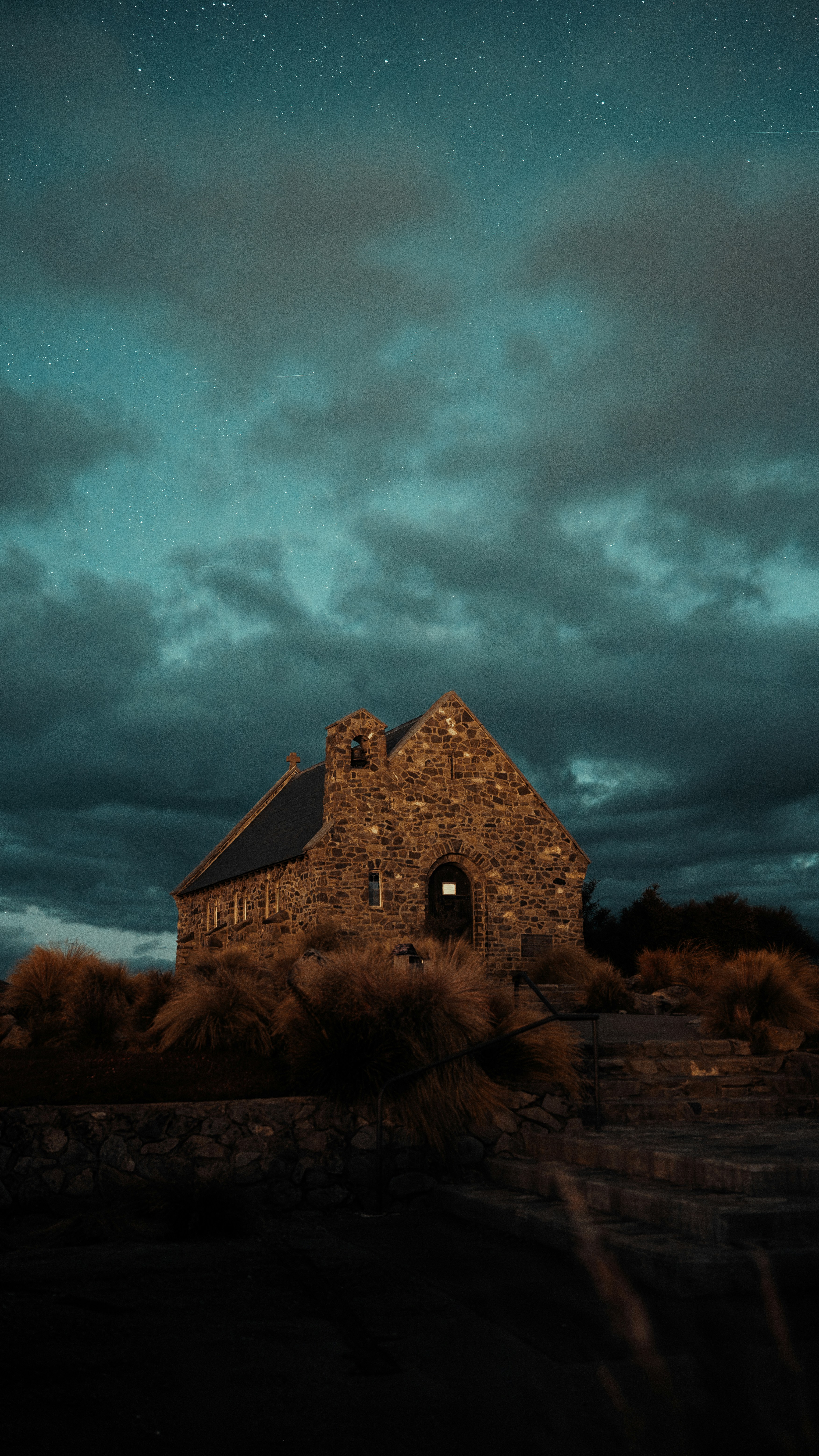 An old church sits on a hill under a cloudy sky