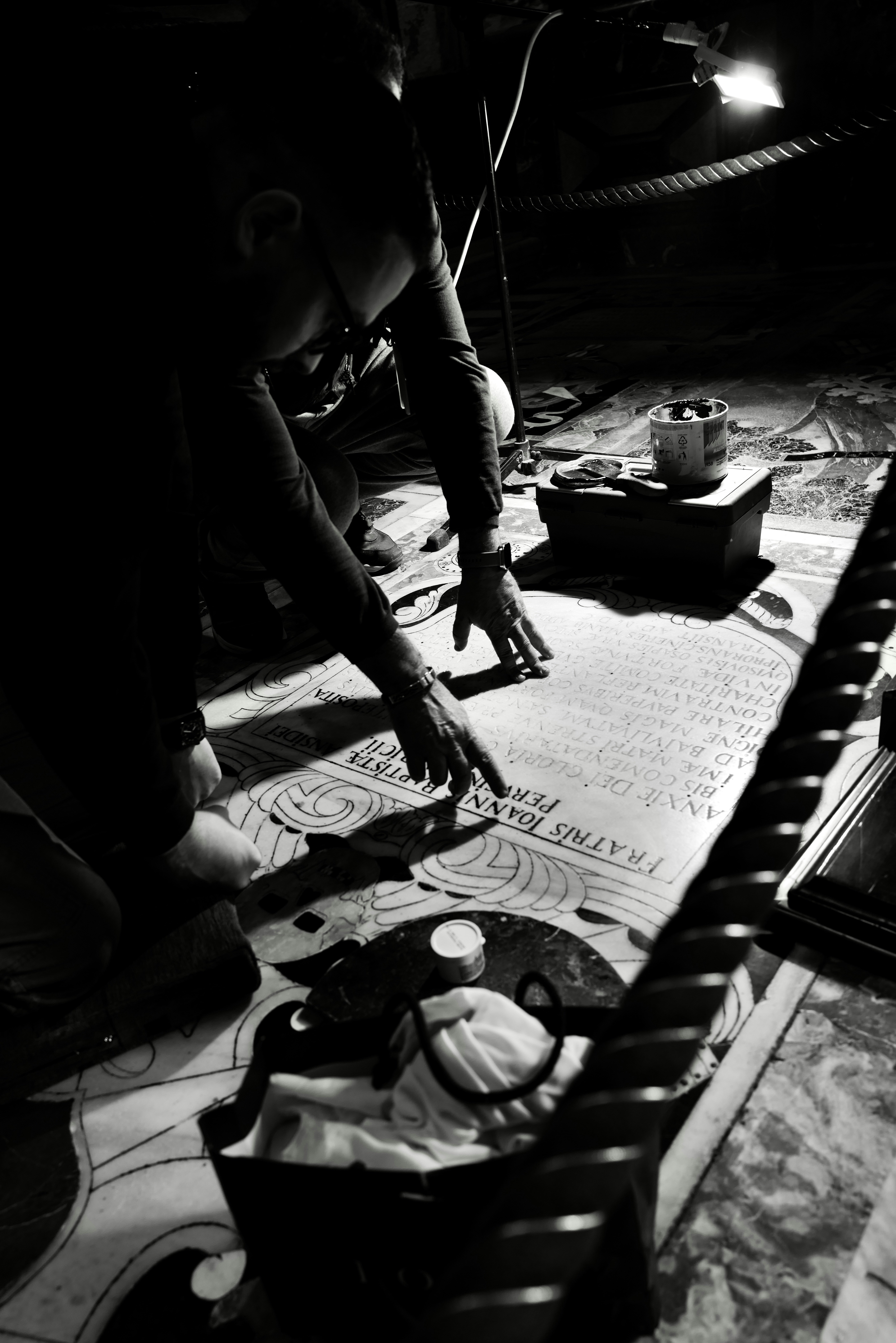 紙に取り組んでいる人の白黒写真