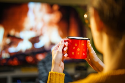 A woman holding a red cup in front of a television