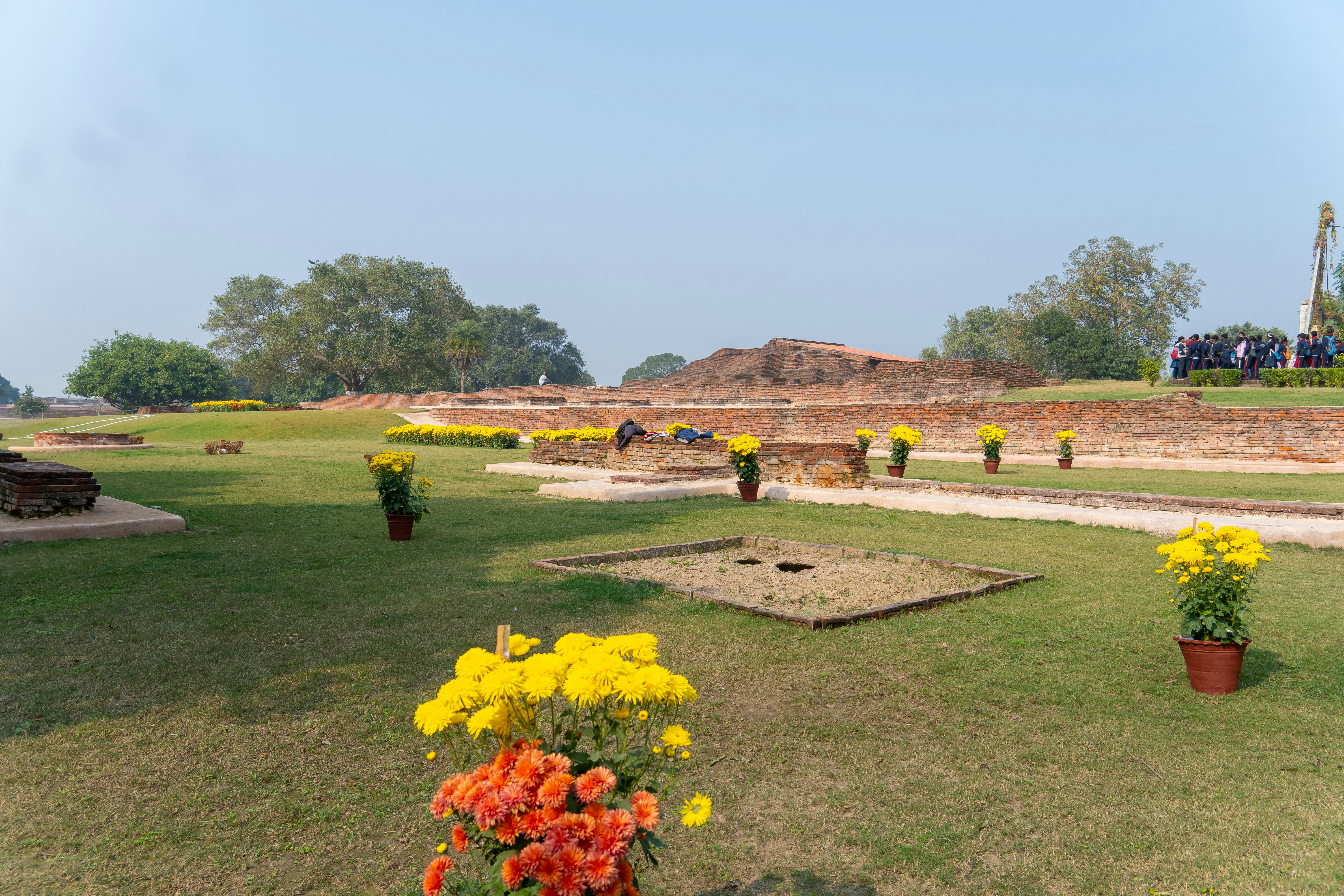 An ancient, intricately carved Shiva temple in a lush green rural setting in Bihar, with a few devotees offering prayers.
