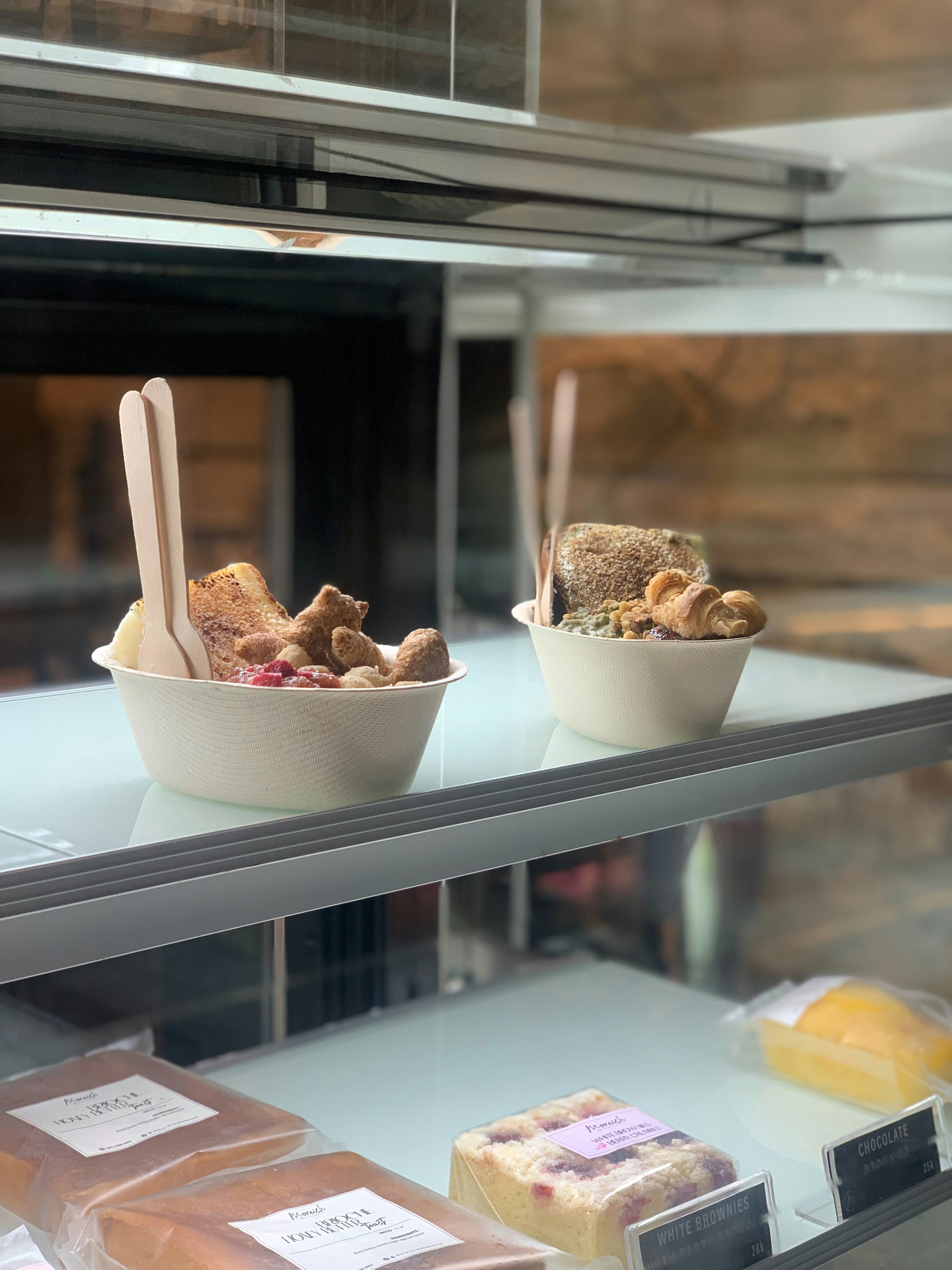 Two bowls of food on a counter in a bakery