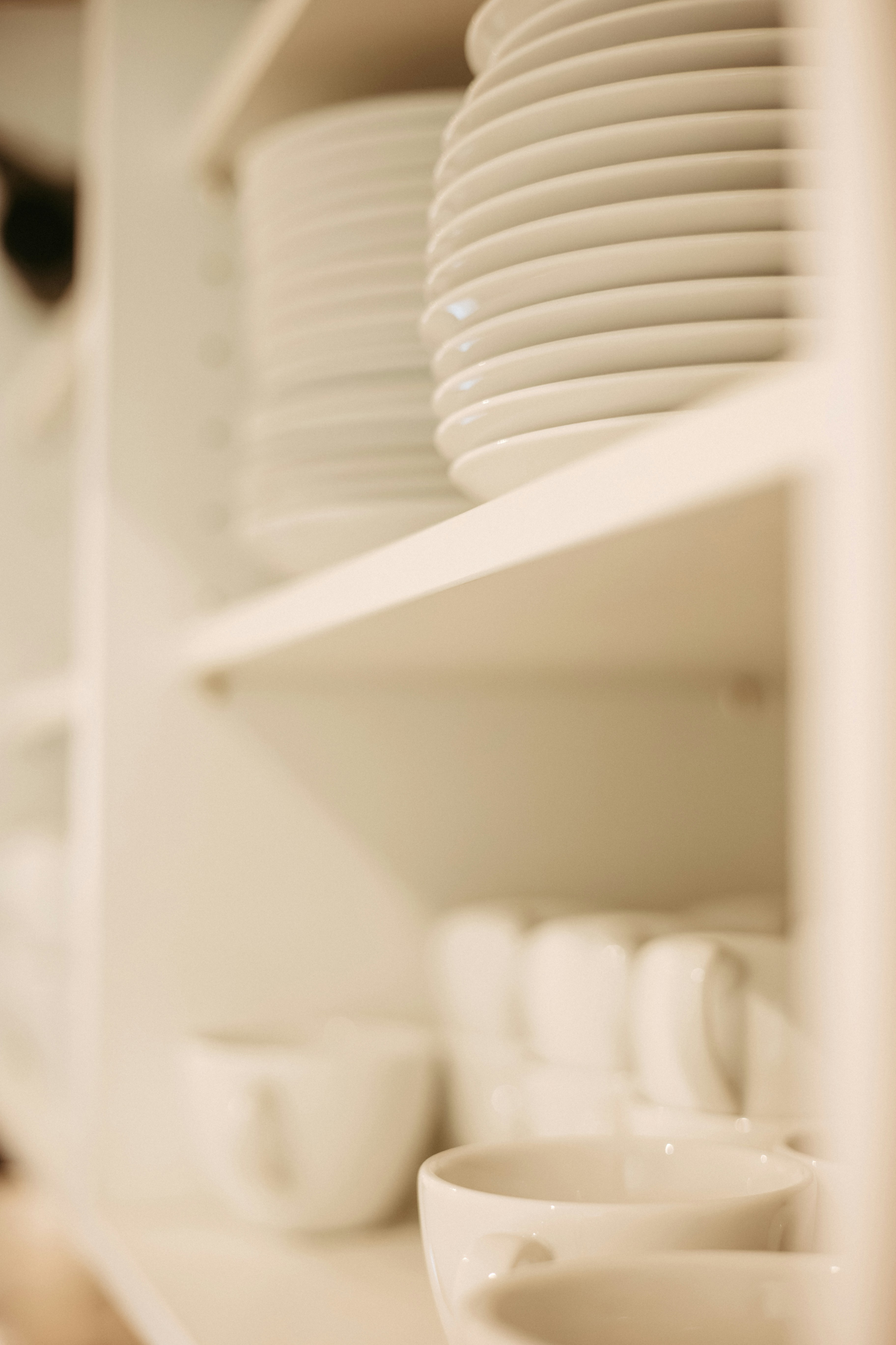 A shelf filled with white plates and bowls