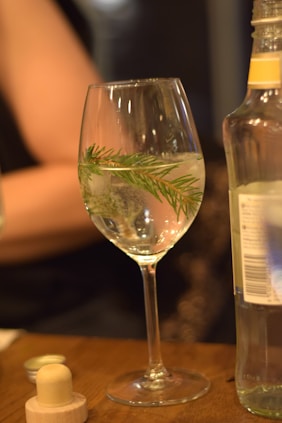 A bottle of wine and a glass of wine on a table