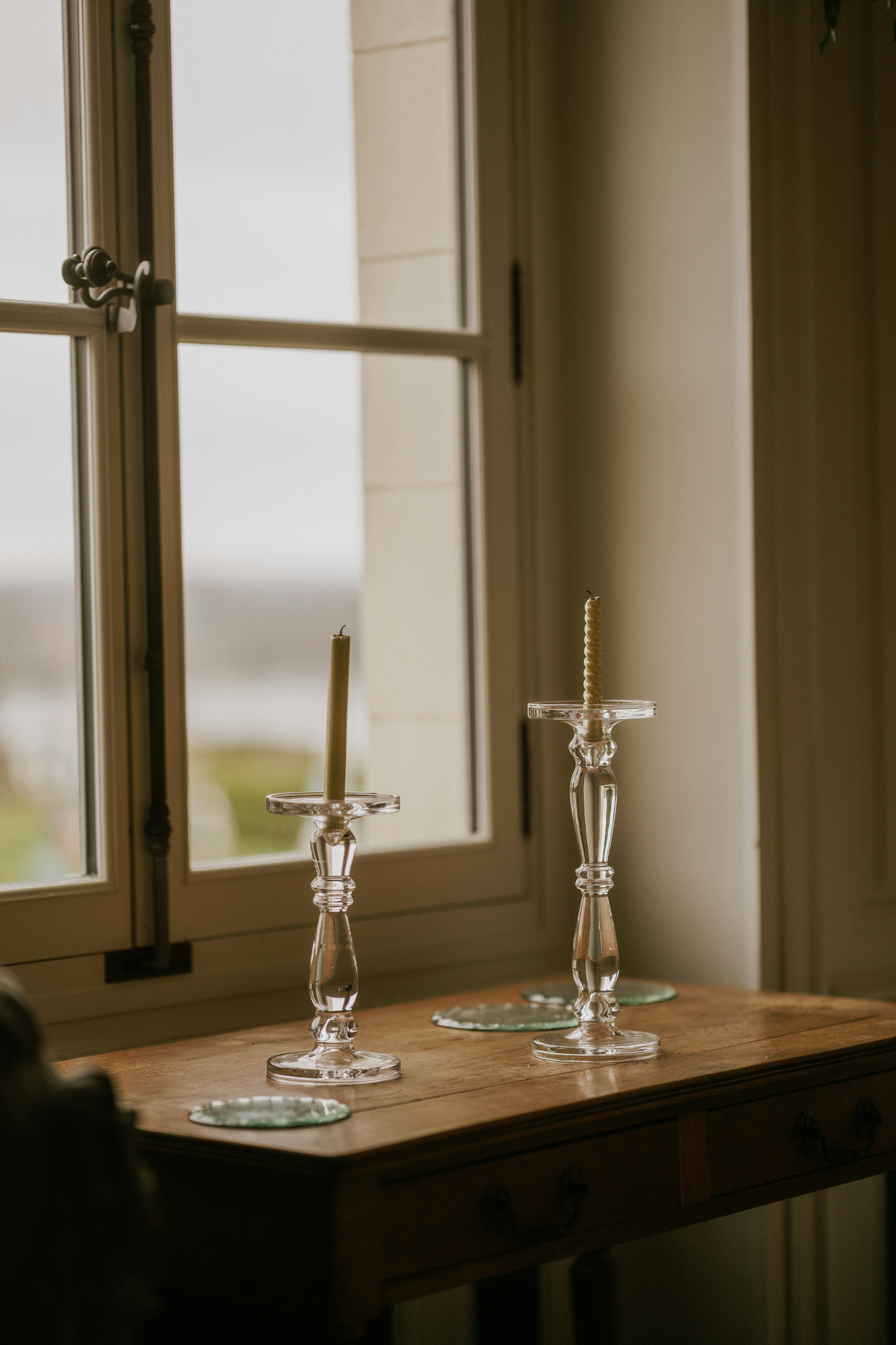 A wooden table with two candles on top of it