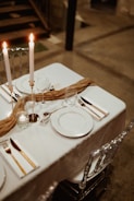 A table set with plates, silverware and candles