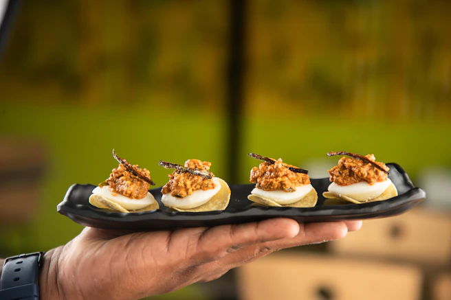 A person holding a plate of deviled eggs