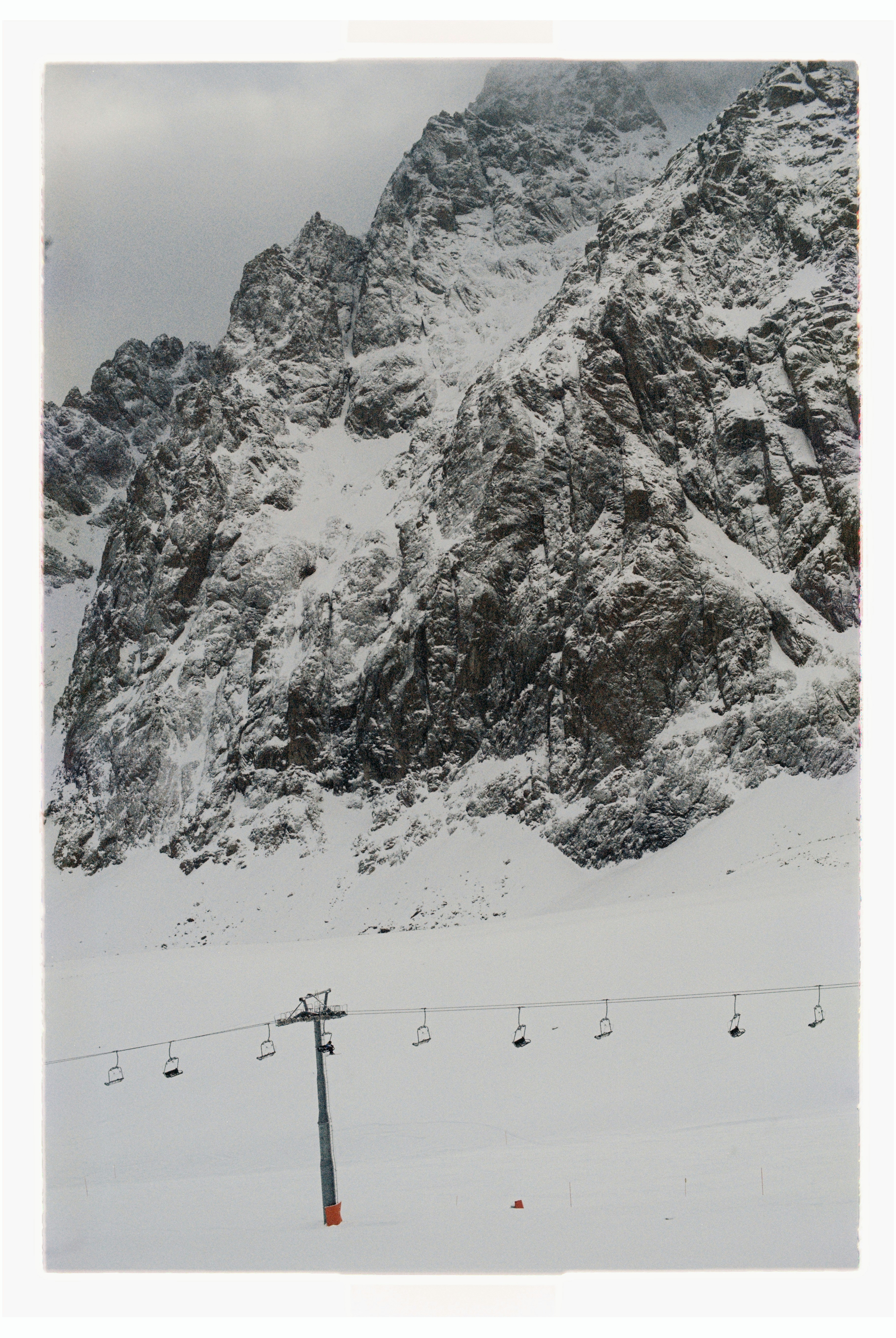 A snowy mountain with a ski lift in the foreground