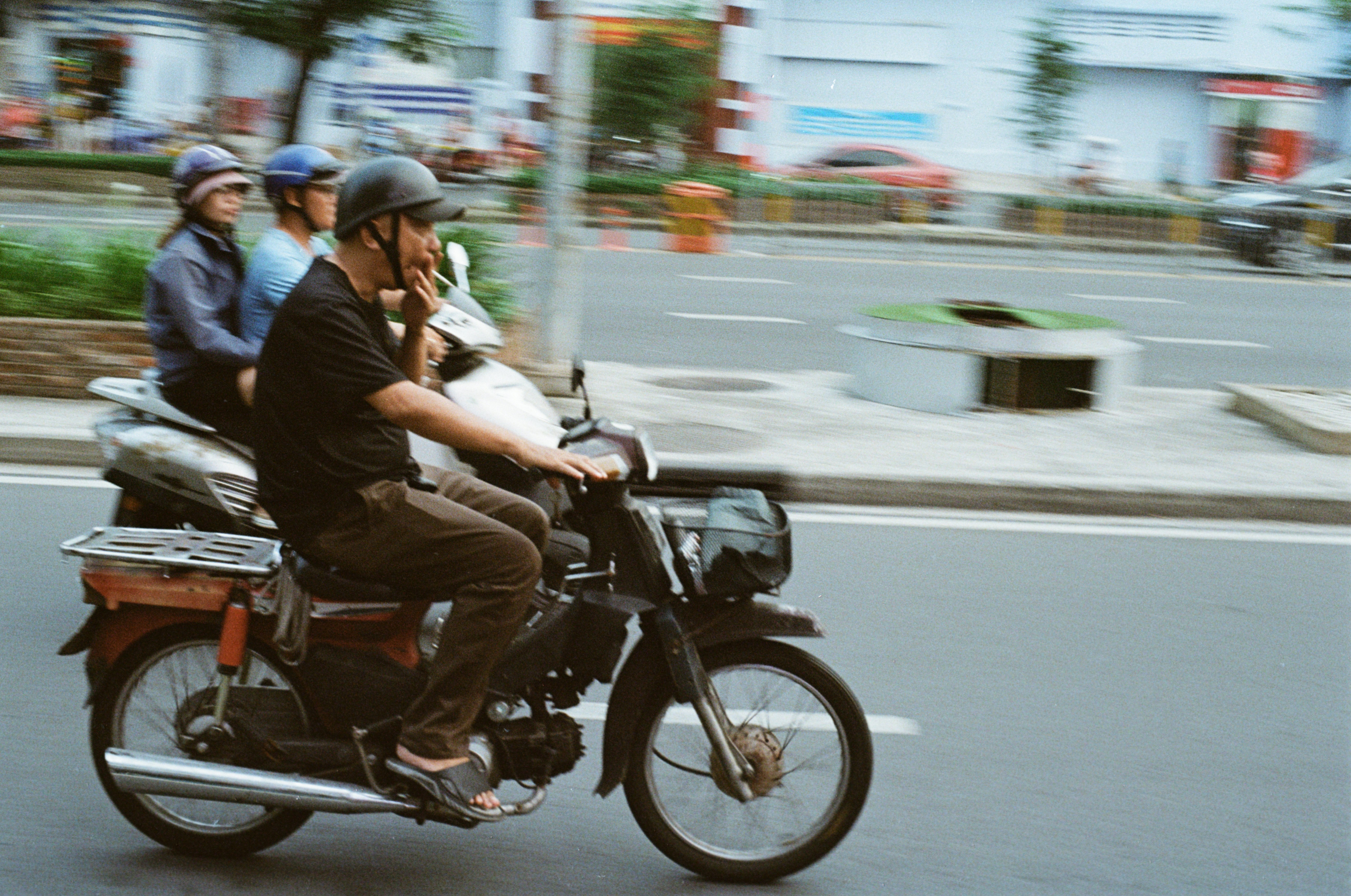 Man smoking a cigarette on a bike. Ho Chi Minh, Vietnam. Shot on Olympus OM-1, Kodak Ultramax 400