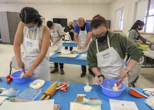 A group of people preparing food in a kitchen