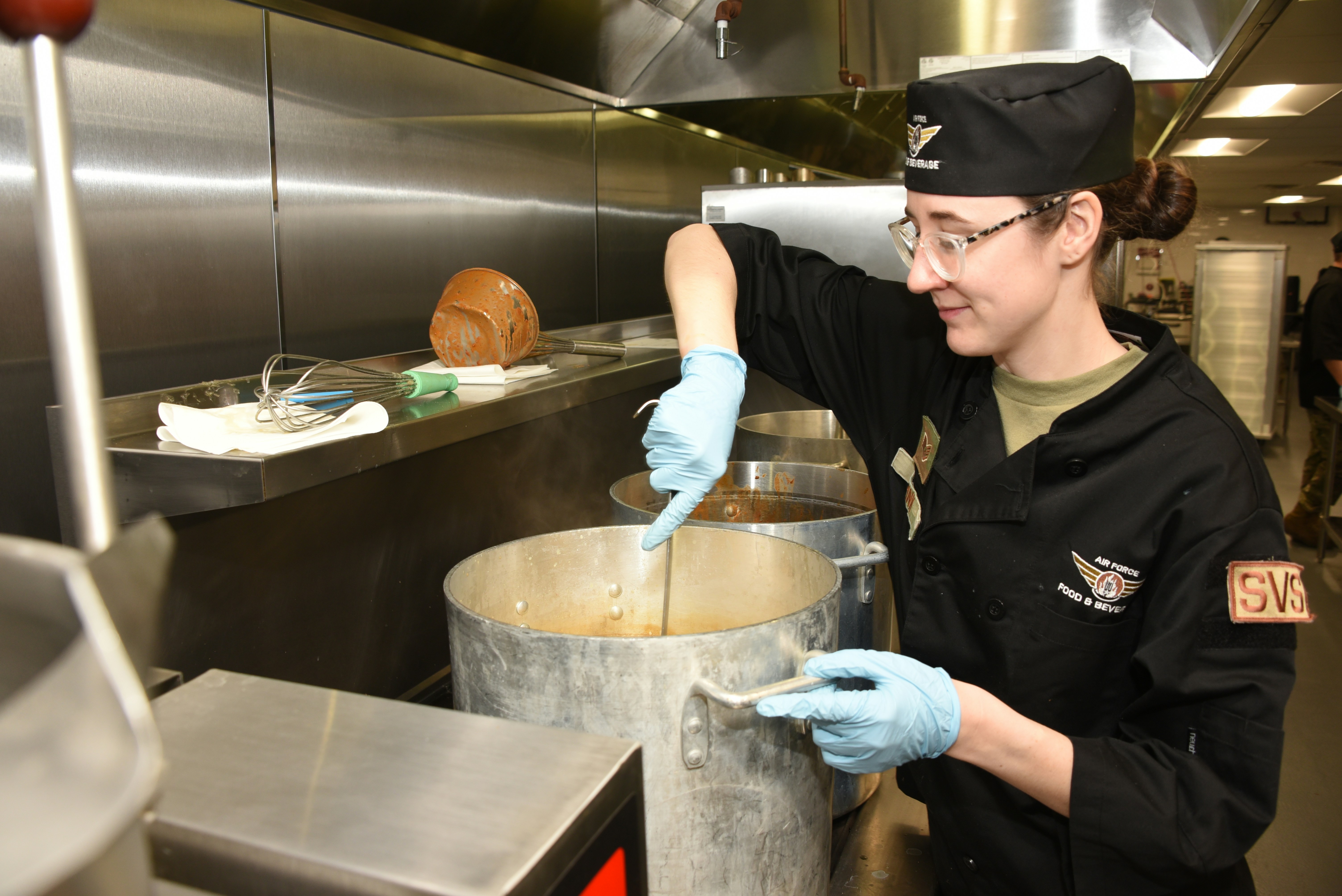 A woman in a kitchen mixing something in a pot